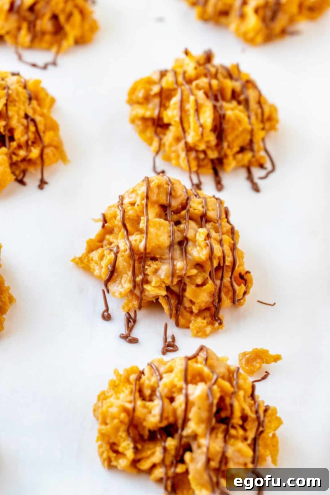 Grandmas Effortless No Bake Cornflake Delights 11 Finished cornflake cookies beautifully drizzled with melted chocolate, showcasing their final, delicious appearance.