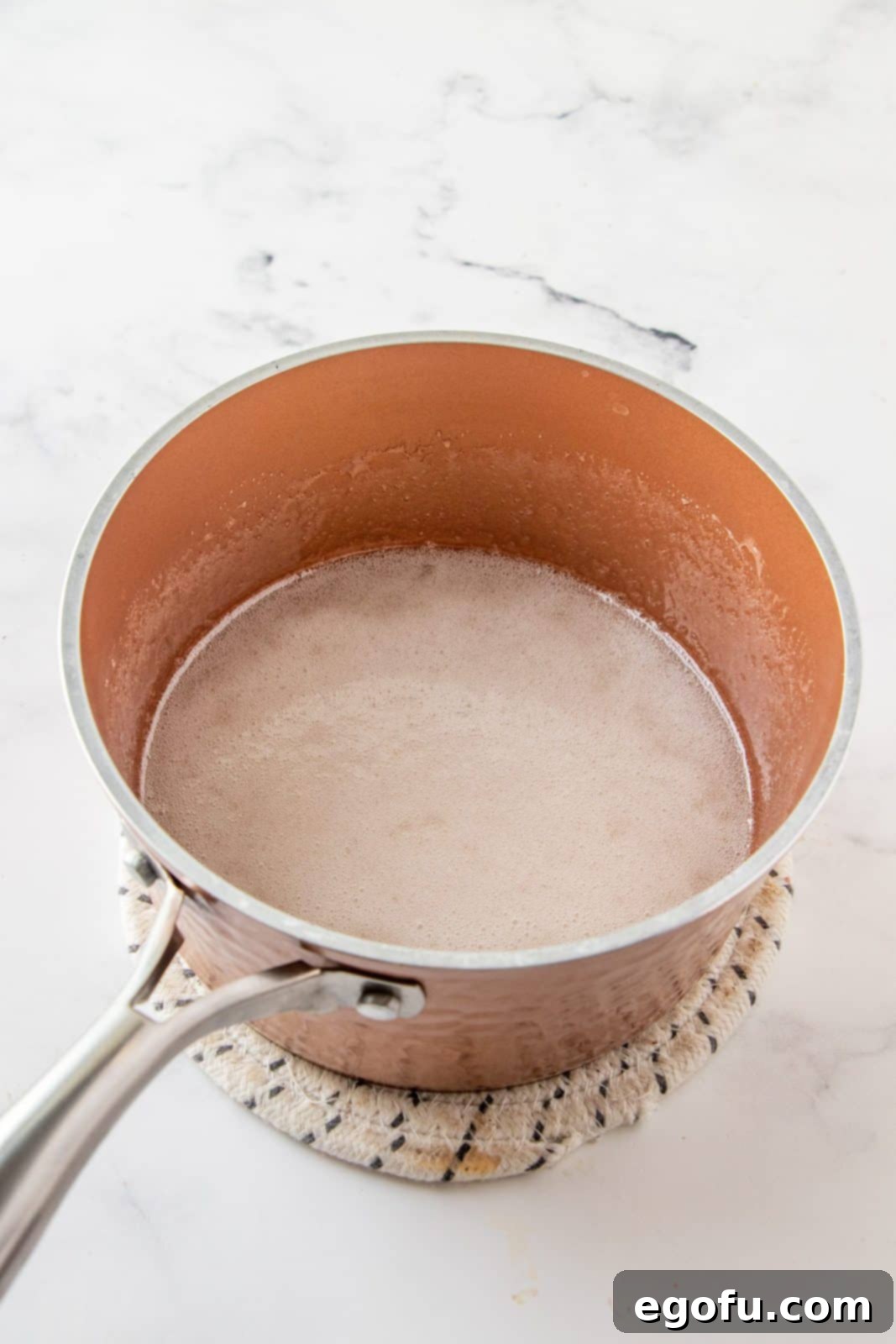 Grandmas Effortless No Bake Cornflake Delights 6 Granulated sugar and light corn syrup gently heating in a pan until completely dissolved, forming a clear, syrupy mixture.