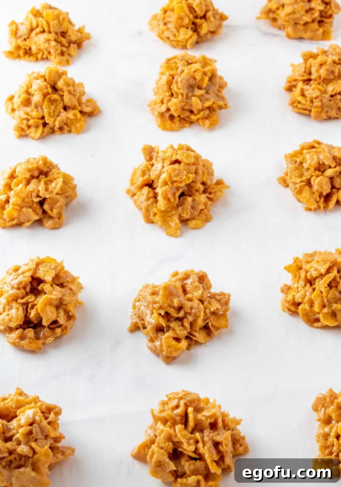 Grandmas Effortless No Bake Cornflake Delights 9 Portioned out cornflake cookies neatly arranged on parchment paper, awaiting their setting time.