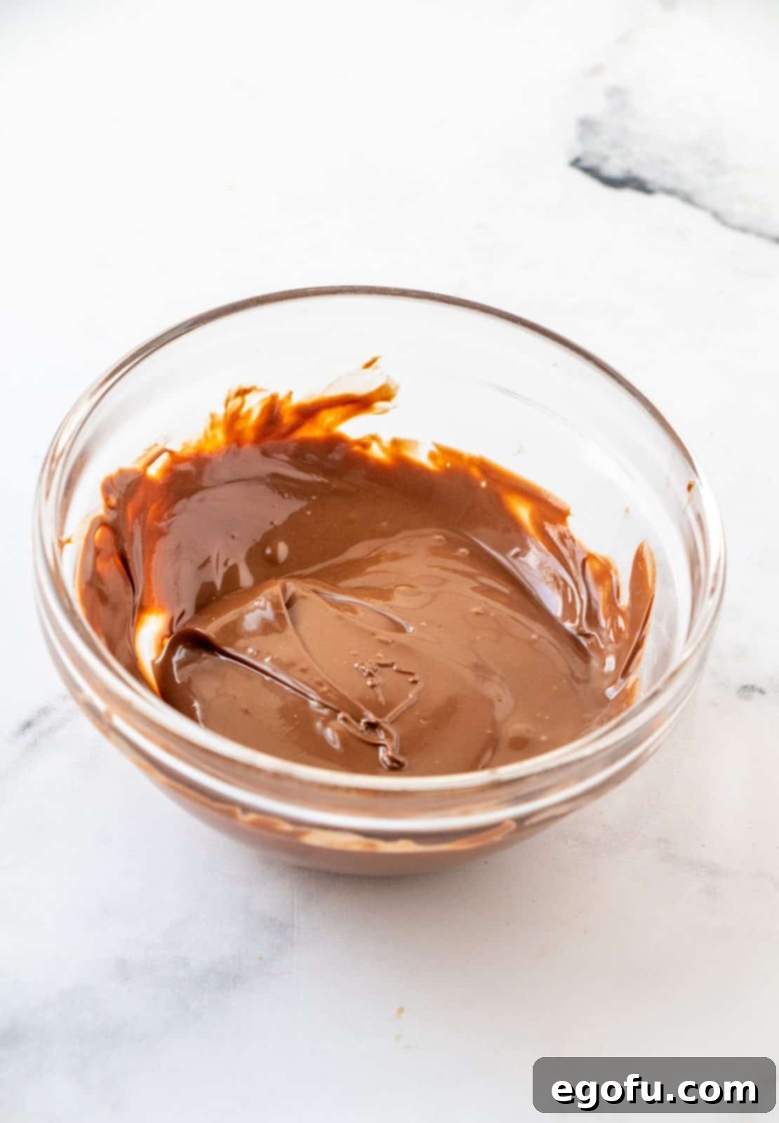 Grandmas Effortless No Bake Cornflake Delights 10 Semi-sweet chocolate chips and oil perfectly melted together in a small bowl, creating a smooth, glossy drizzle.