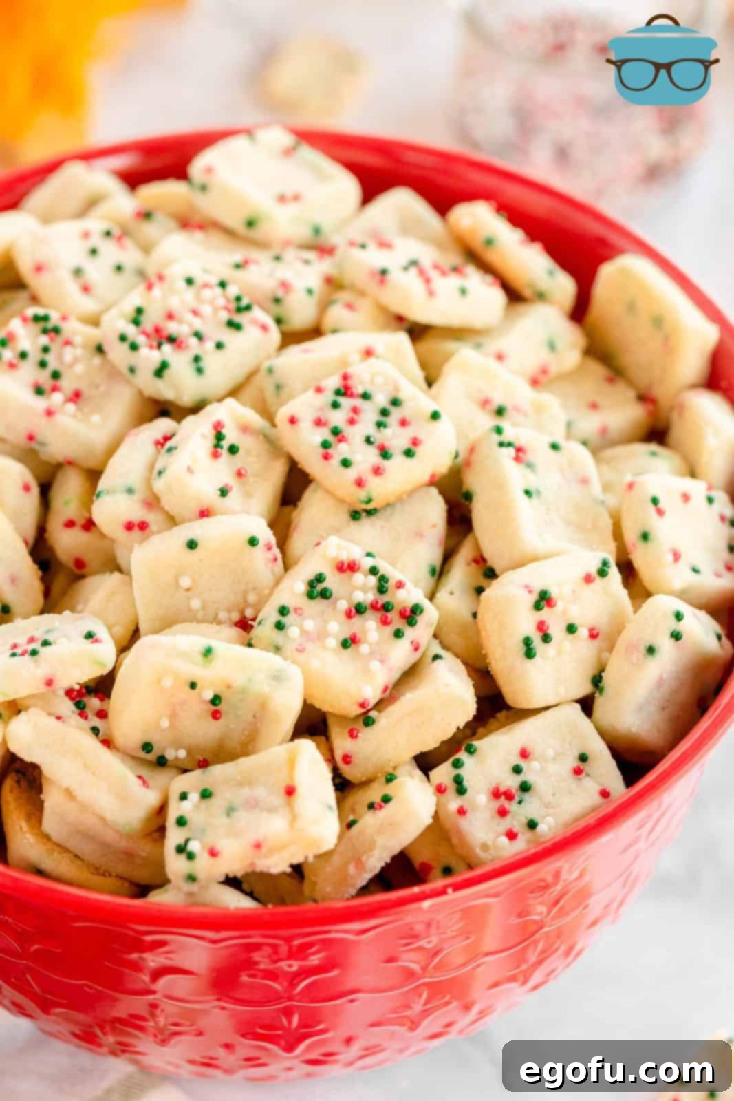 Mini Christmas Shortbread Cookies in red bowl, perfectly baked and adorned with festive sprinkles.
