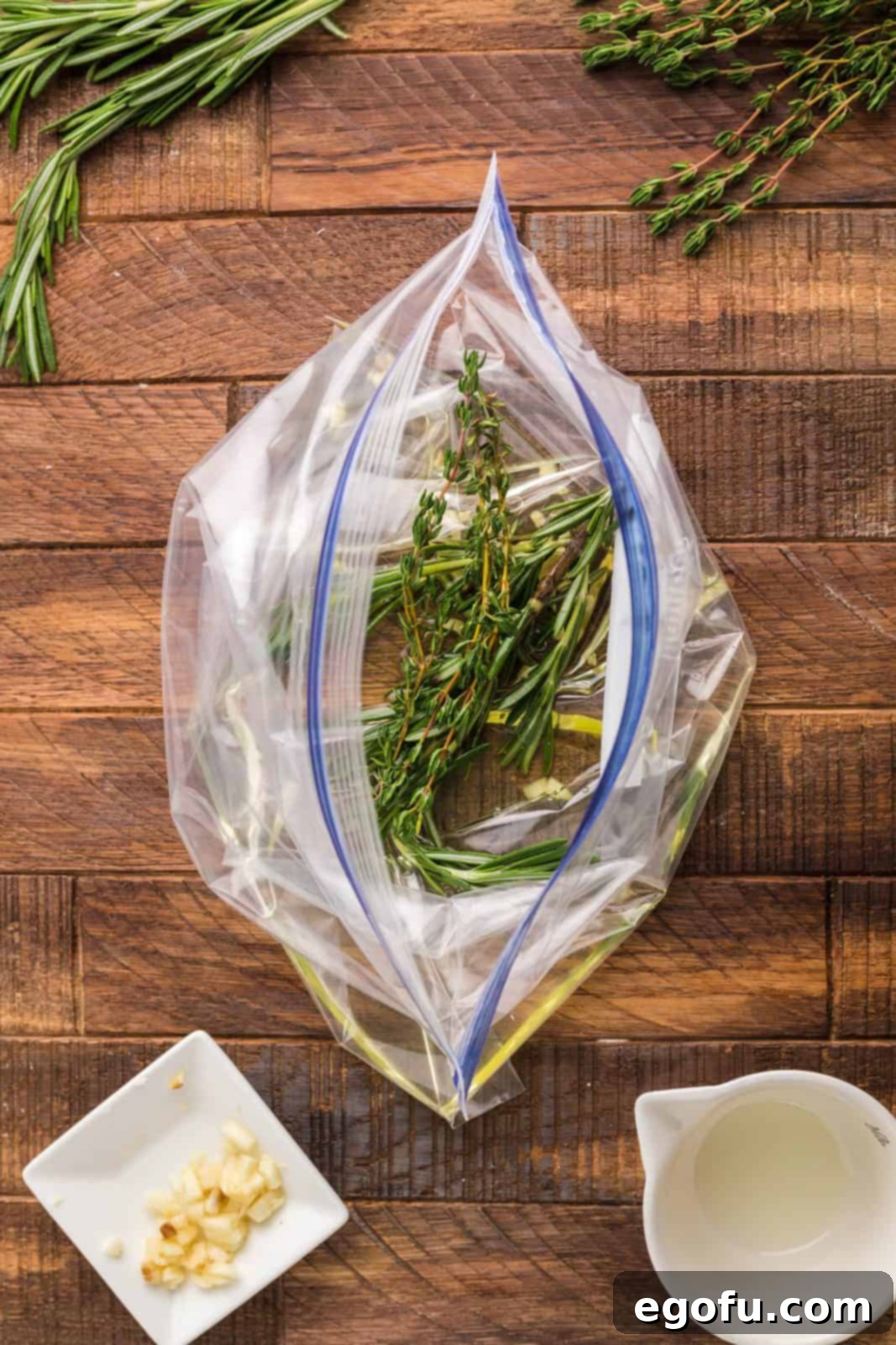 Succulent Lamb Chops 5 Grapeseed oil, crushed garlic cloves, and fresh rosemary sprigs being added to a resealable bag, ready for the lamb marinade.