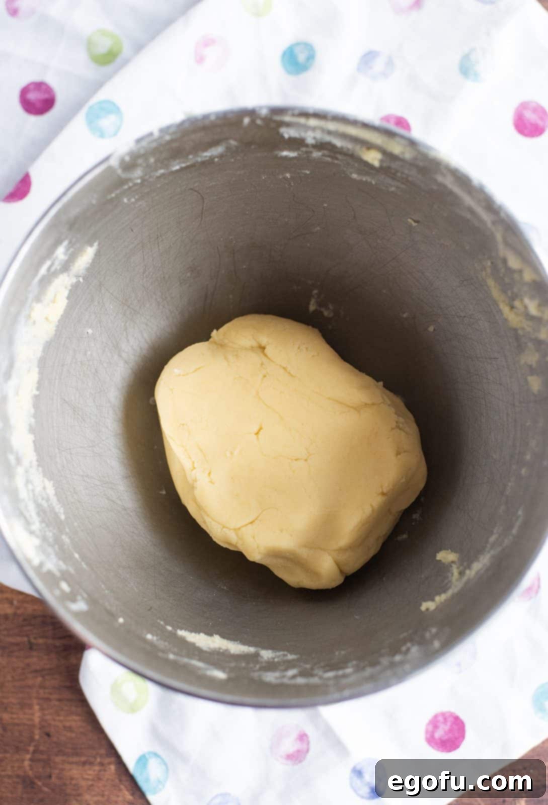 All-purpose flour being gently mixed into the cookie batter to form a soft, cohesive dough.