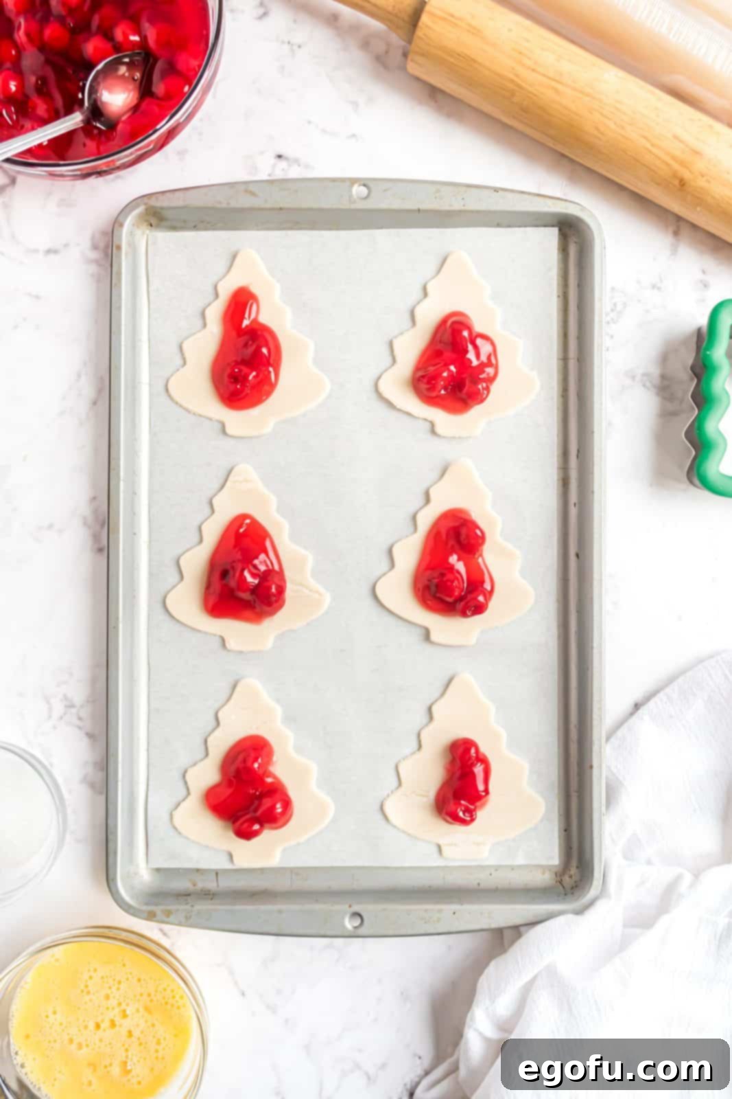 Cherry pie filling added to bottom pie crust cut into a Christmas tree shape.