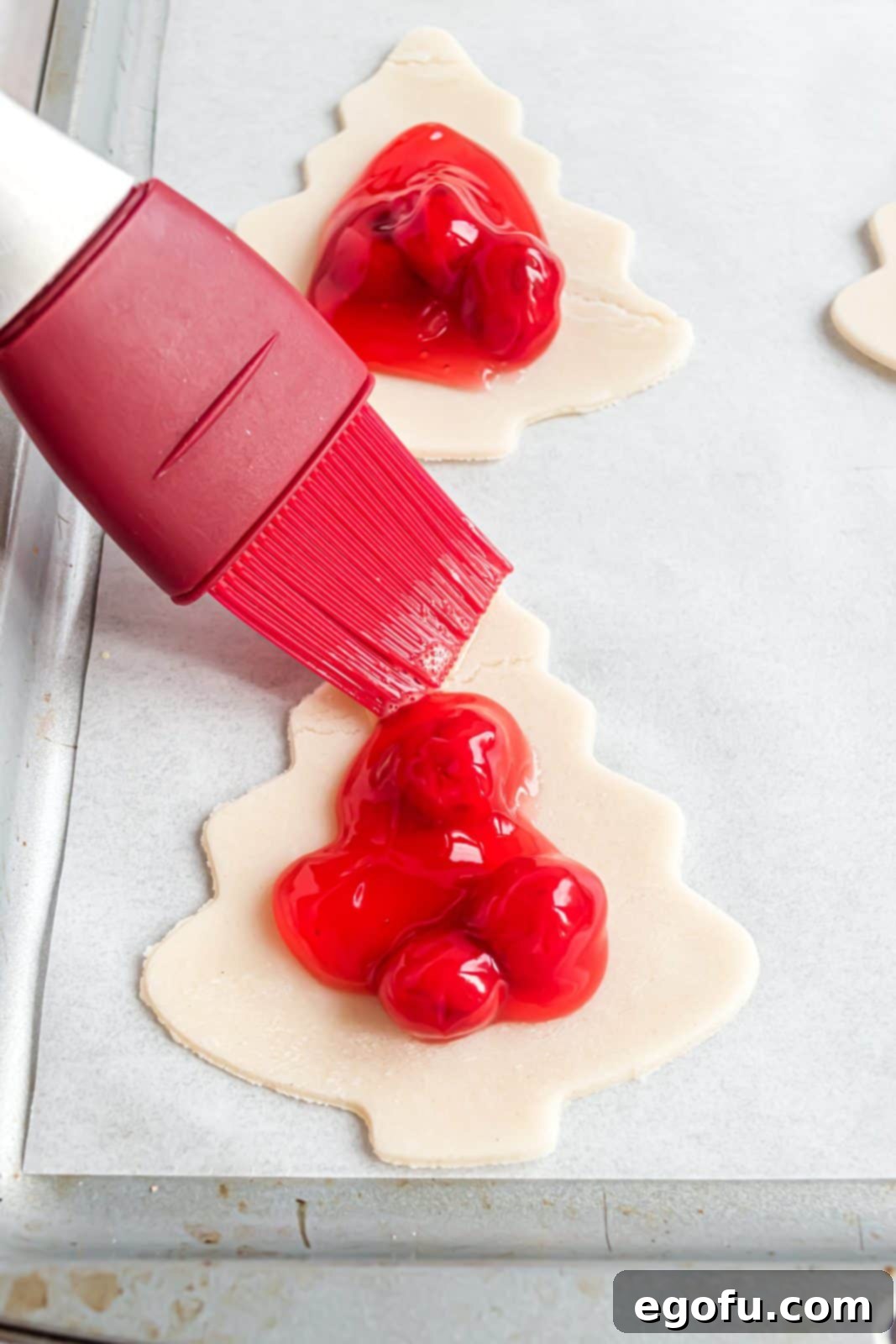 Egg and water mixture being brushed around edges of pie crust to seal the hand pie.