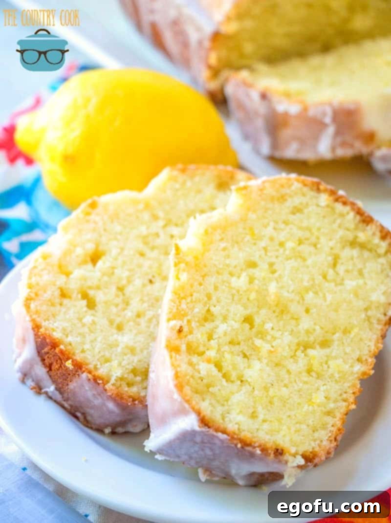 Starbucks Zesty Lemon Loaf 11 Two perfectly sliced lemon loaf portions on a white plate, with a fresh lemon in the background, ready to enjoy.