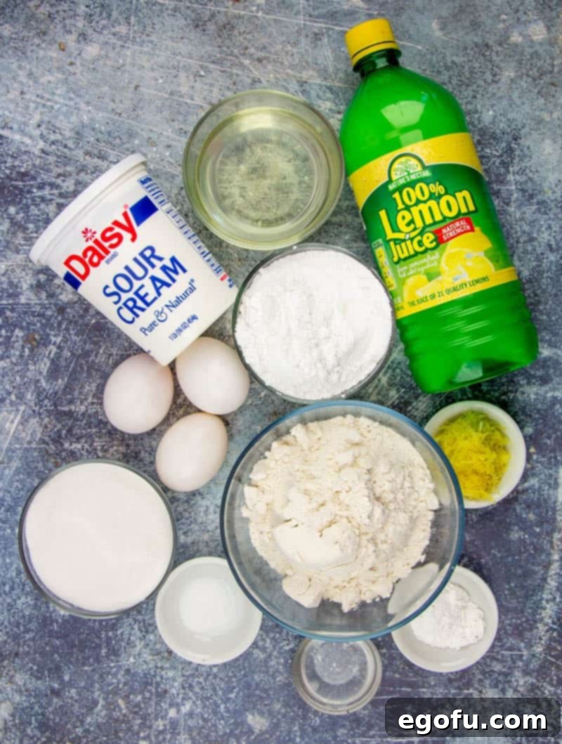 Starbucks Zesty Lemon Loaf 5 A flat lay photo showing ingredients: lemon juice, flour, sour cream, eggs, sugar, lemon zest, oil, and powdered sugar.