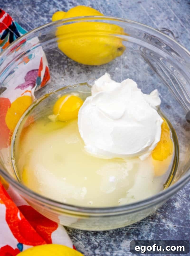 Starbucks Zesty Lemon Loaf 6 Eggs, sugar, sour cream, and oil are mixed together in a large bowl, creating a smooth batter.