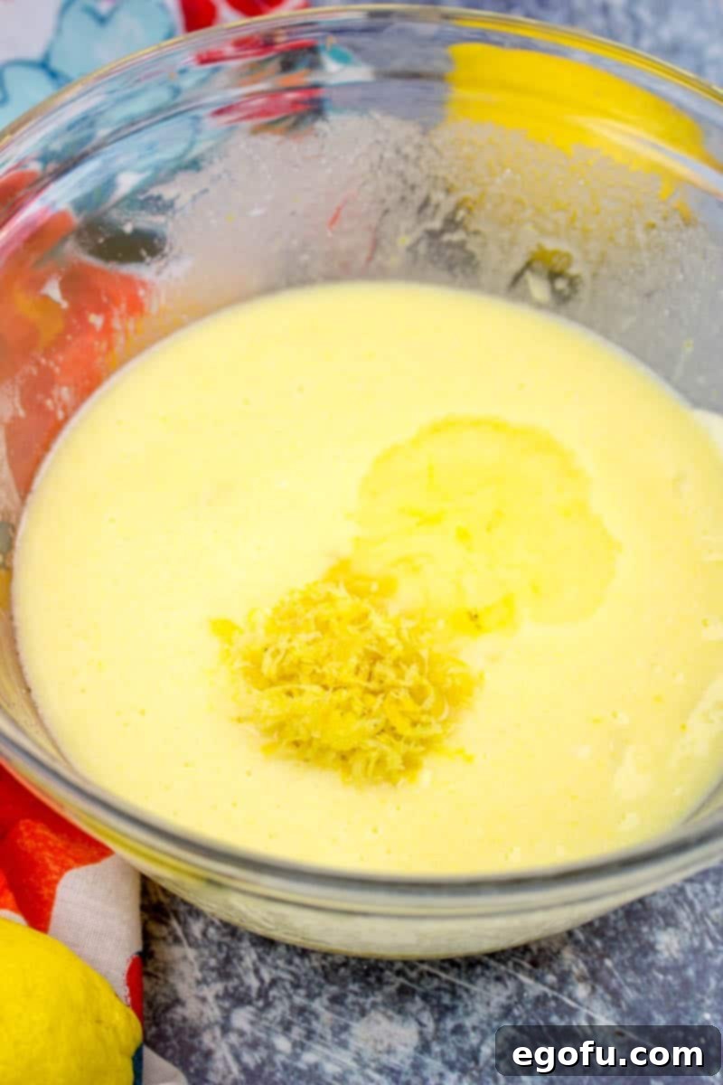 Starbucks Zesty Lemon Loaf 7 Lemon juice and lemon zest are added to the lemon cake batter in a clear bowl, enhancing the citrus flavor.