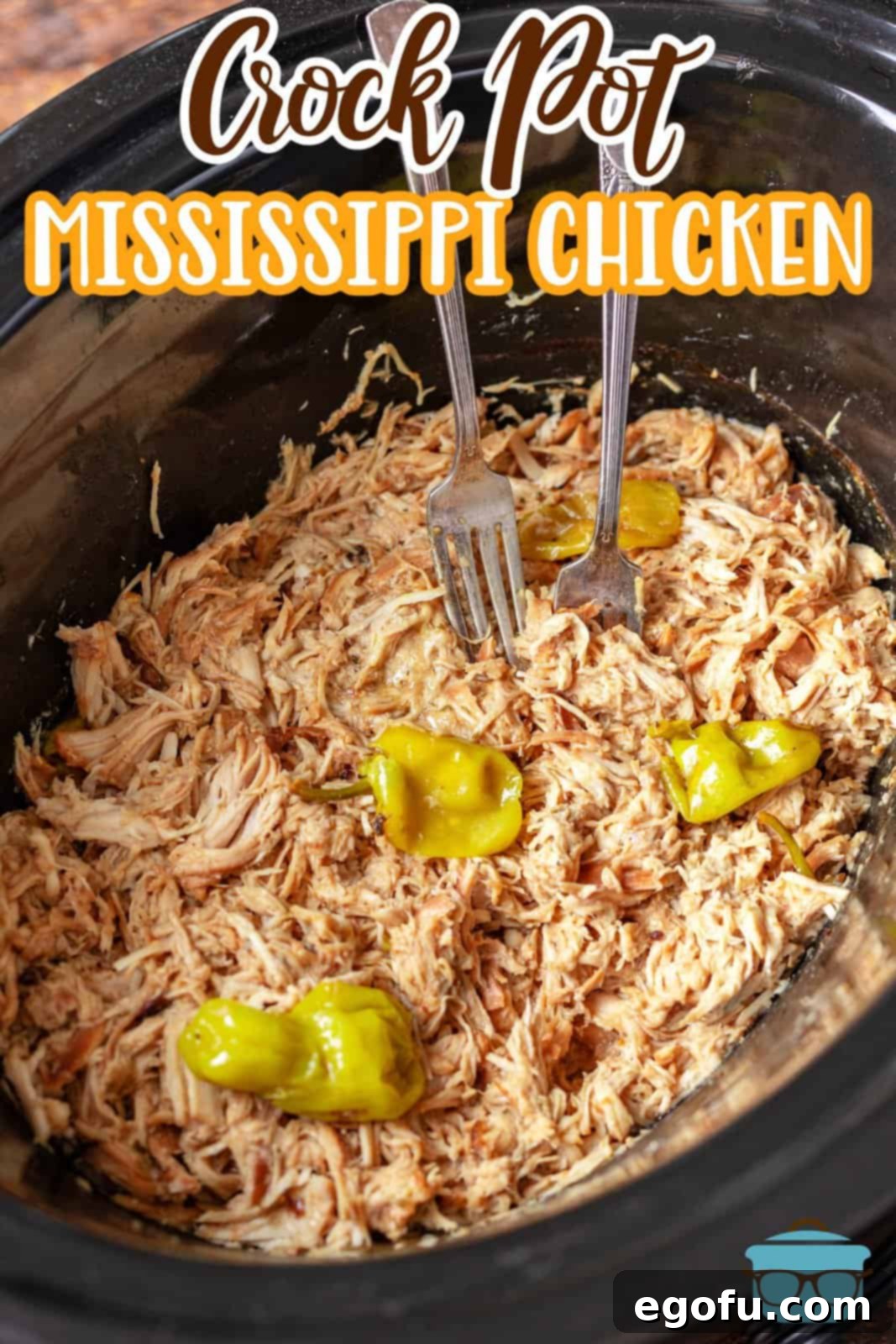 Crock Pot Mississippi Chicken shown shredded in a slow cooker with pepperoncini peppers.