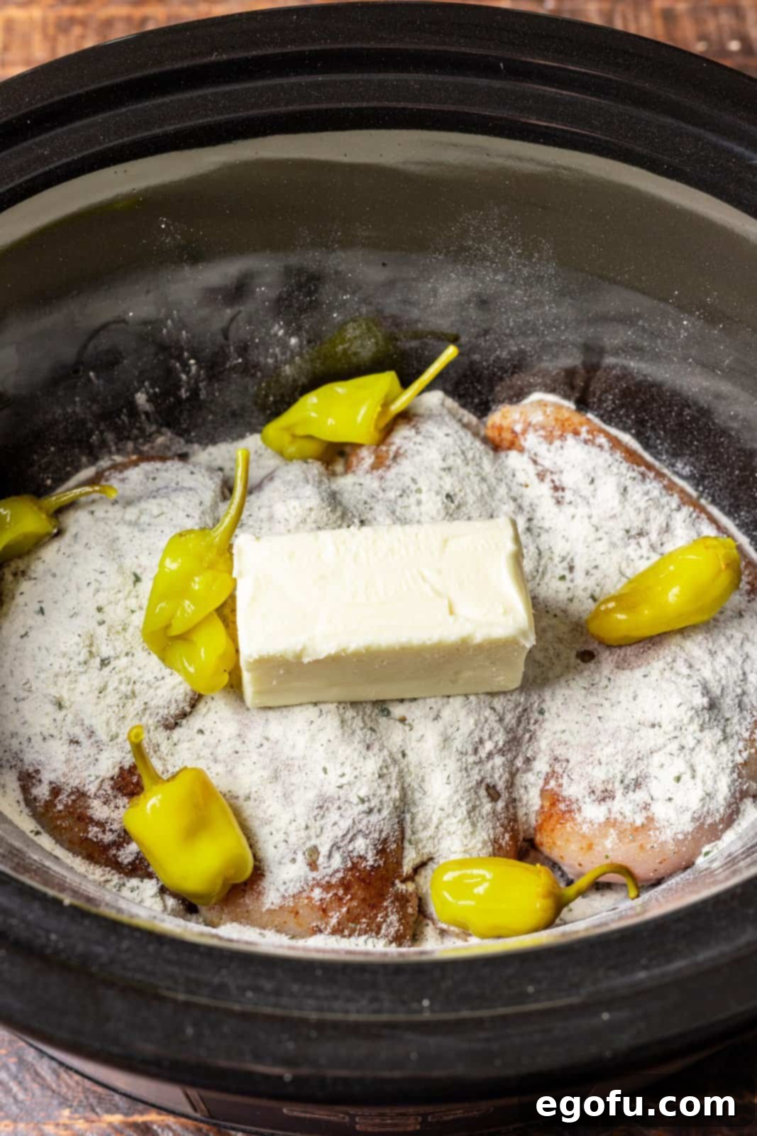 au just gravy, dry ranch dressing, pepperoncini peppers and salted butter on top of chicken breasts in a slow cooker. 