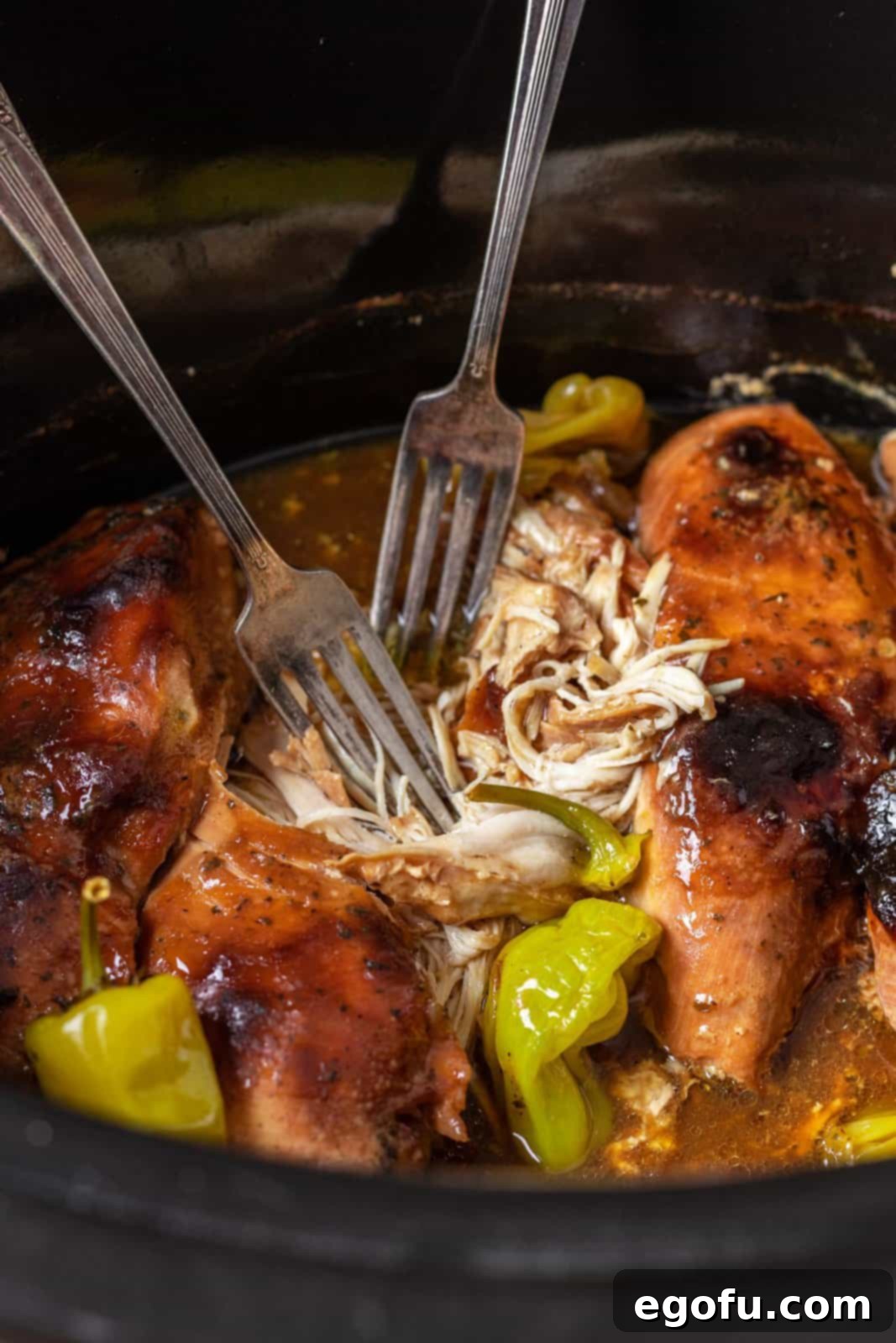Slow cooker cooking, lid on, chicken inside.