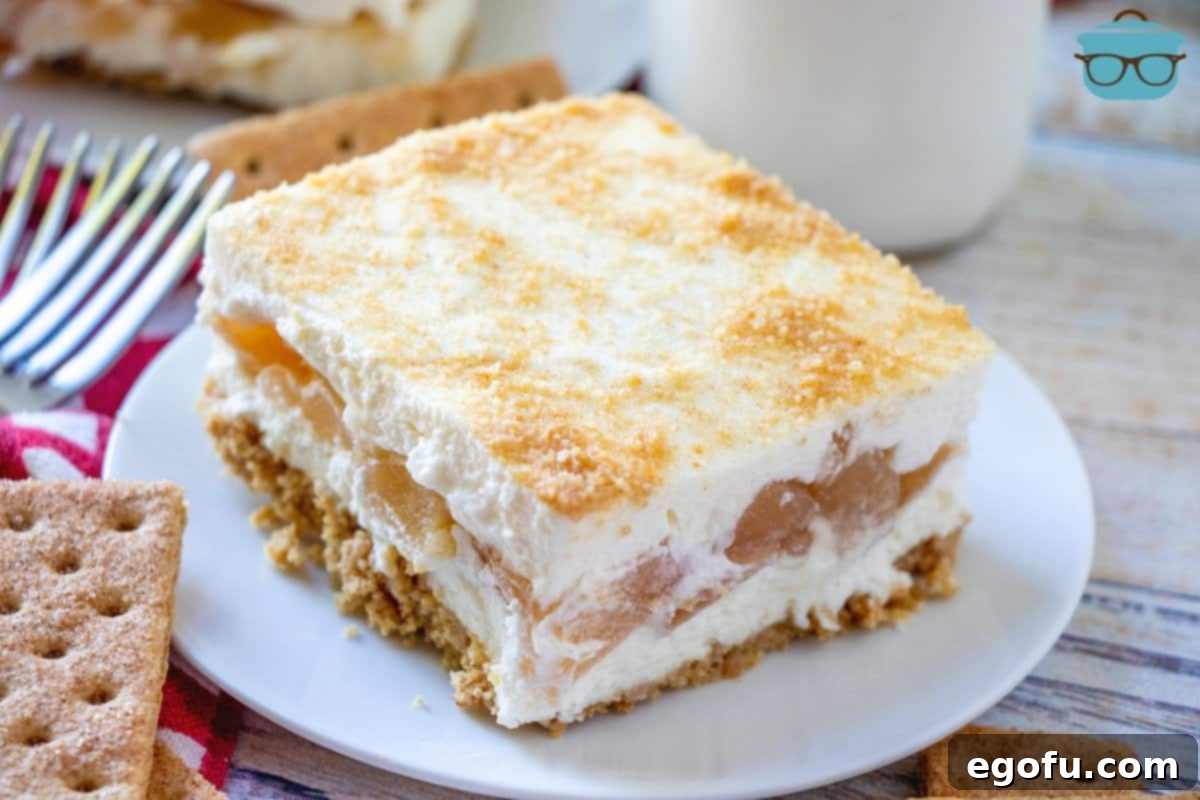 Slice of No-Bake Apple Yum Yum dessert on a small white plate with a bottle of milk in the background.