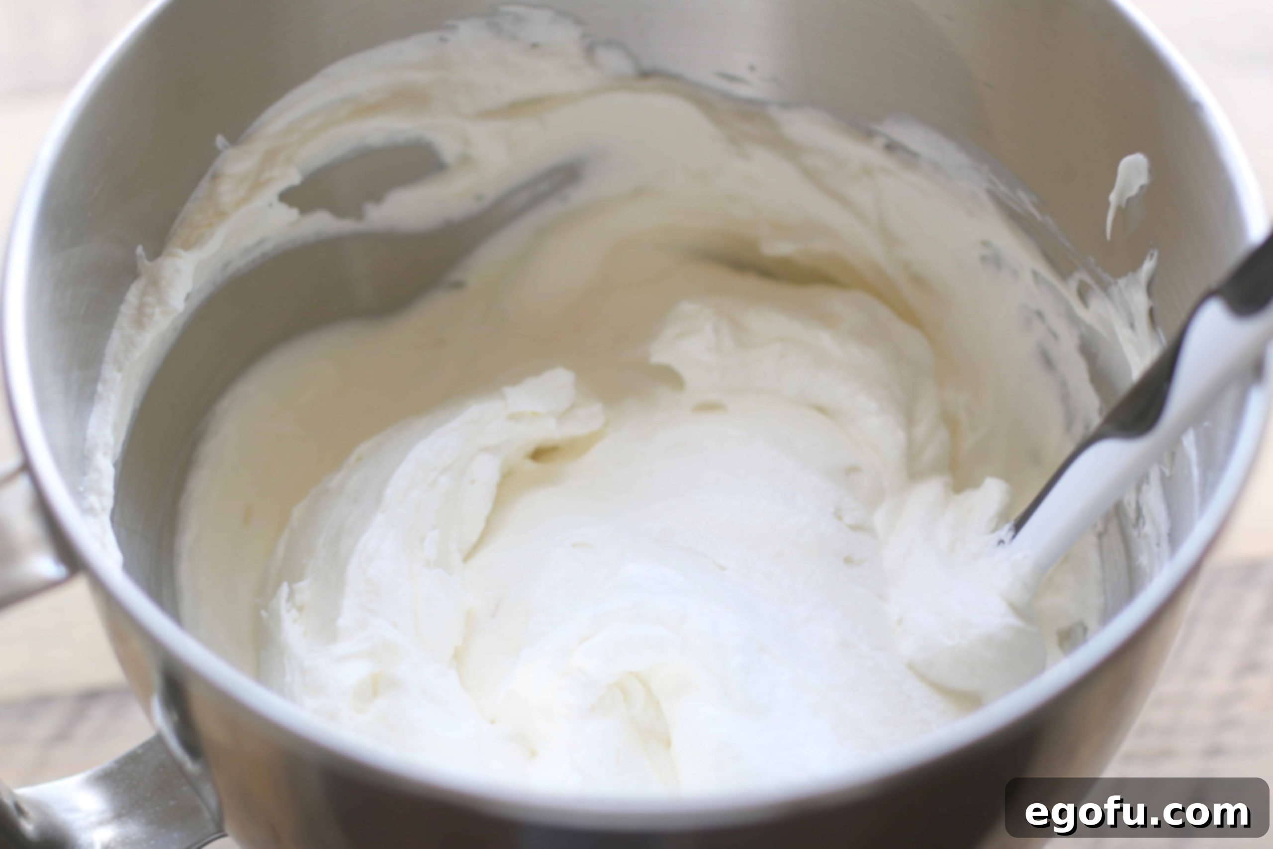 Homemade whipped cream combined with whipped sweetened cream cheese in a large bowl.