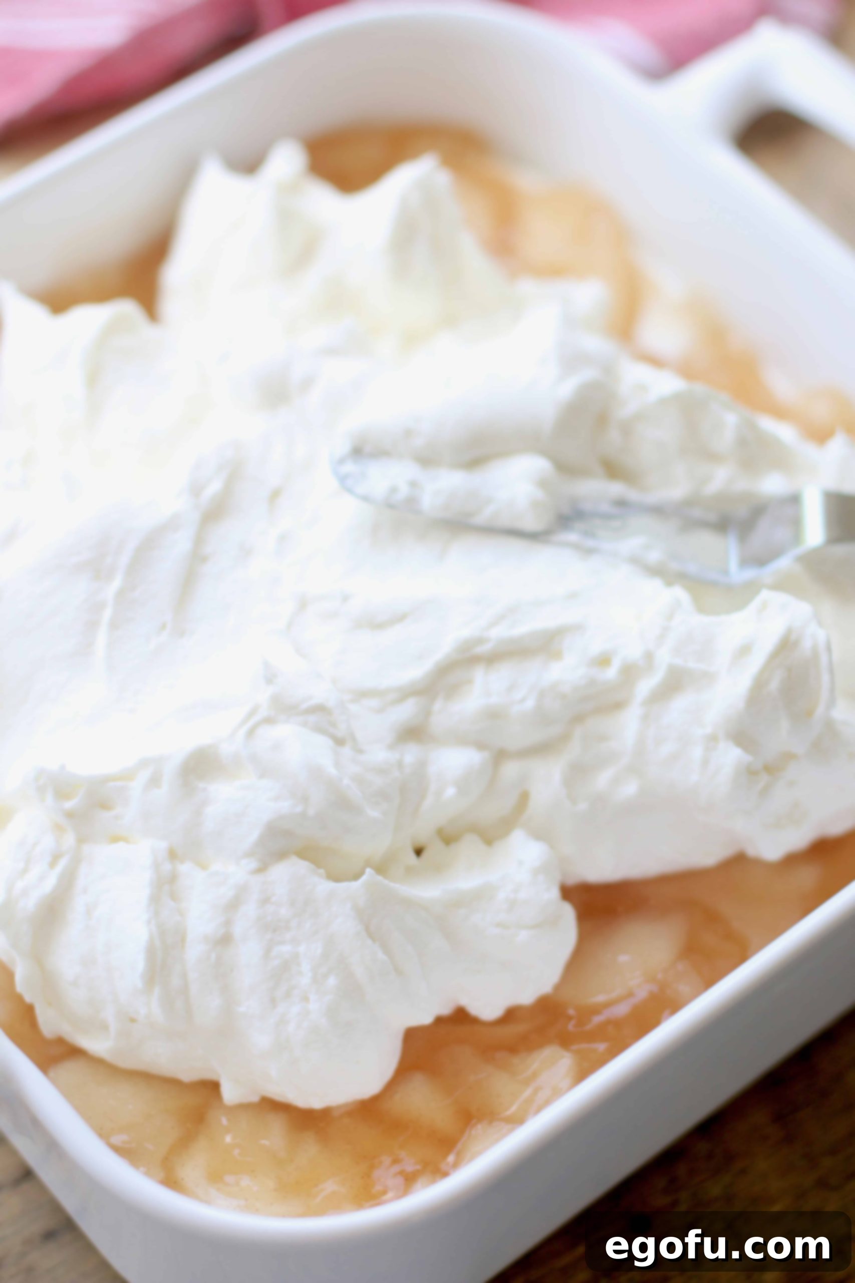 Sweetened whipped cream cheese layer spread on top of apple pie filling layer.