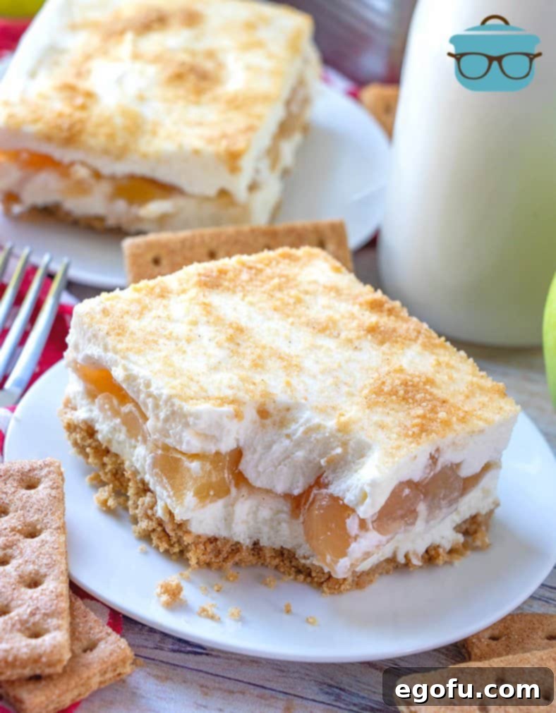 No Bake Apple Yum Yum dessert, slice shown on a white plate with a small bite removed from the corner of the dessert.