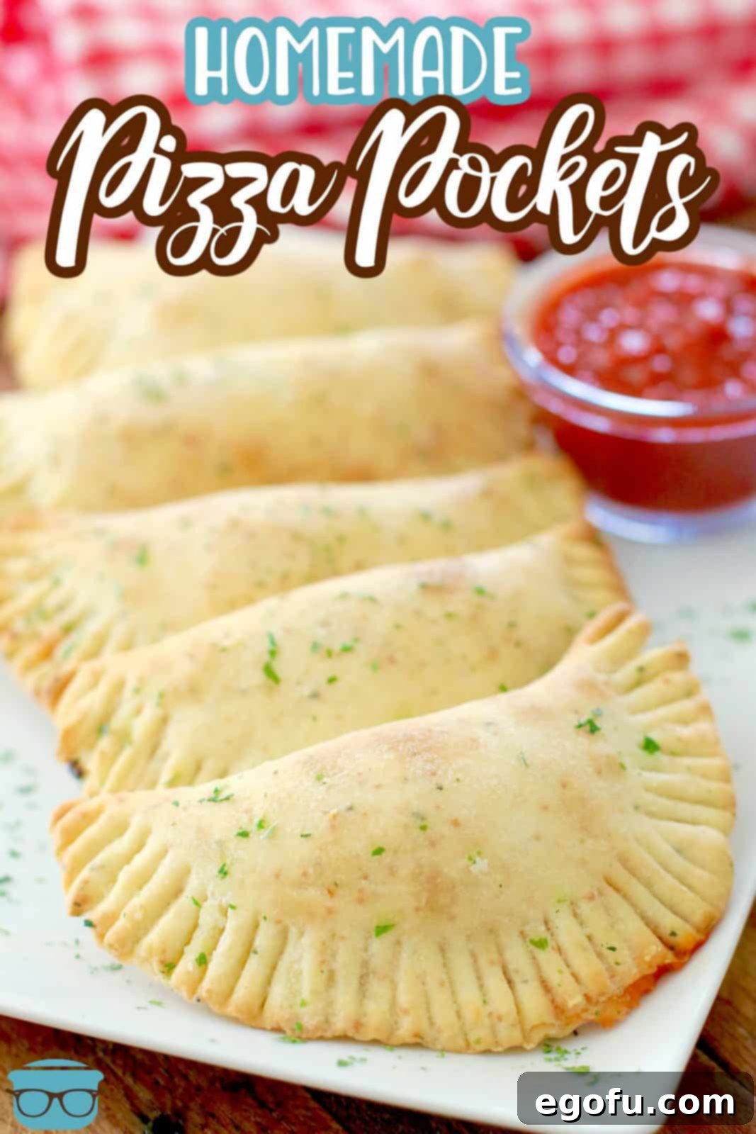 Homemade Pizza Pocket recipe. Hot pockets shown lined up on a white platter with a small bowl of pizza sauce, ready to be served.