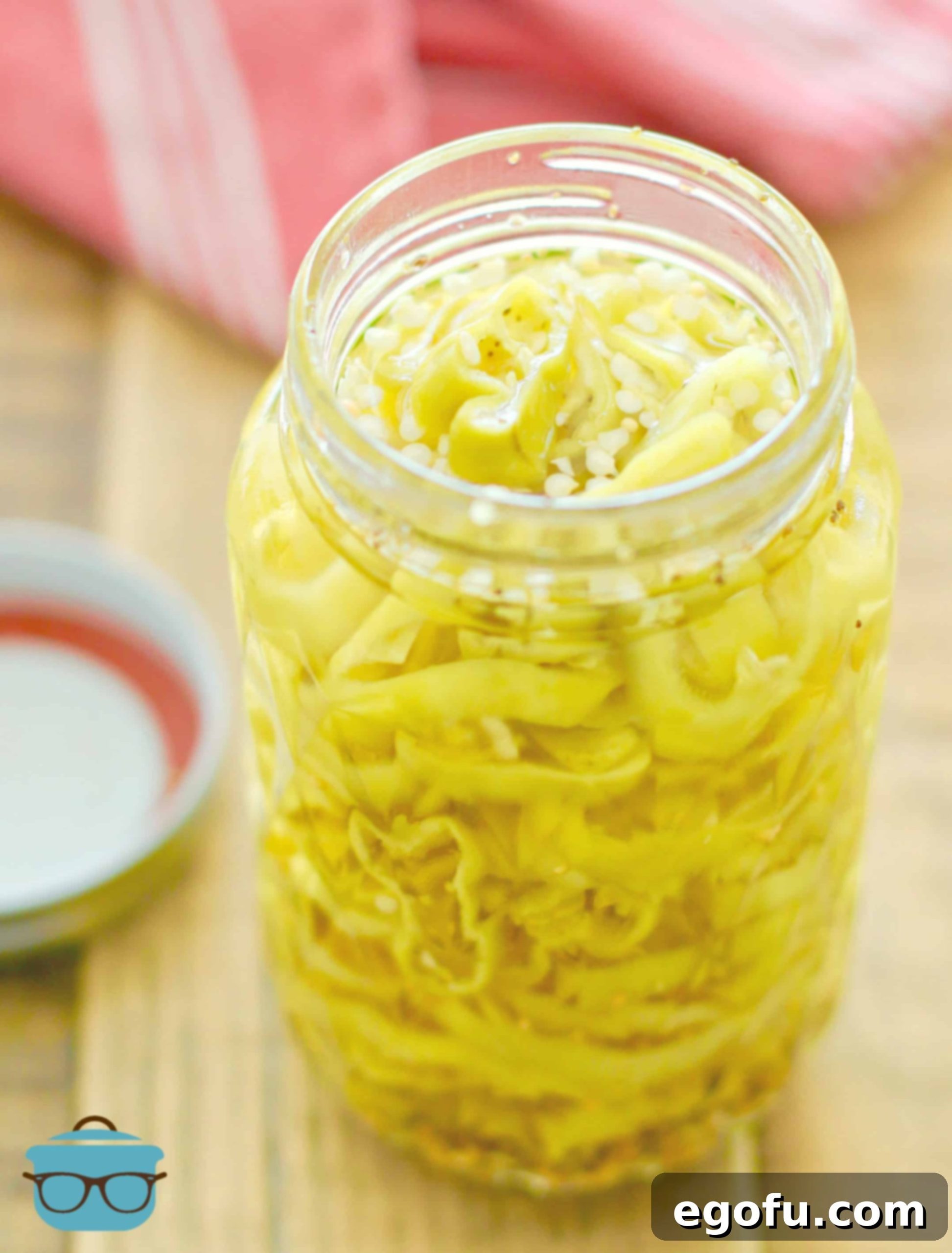 EASY PICKLED BANANA PEPPERS IN A PINT-SIZED CANNING JAR, showcasing their vibrant color.