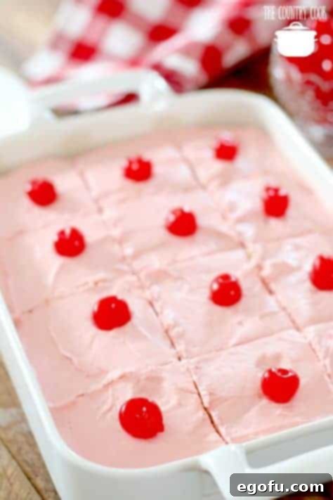 Close-up of Maraschino Cherry Cake slices garnished with bright red maraschino cherries on top, ready for serving.