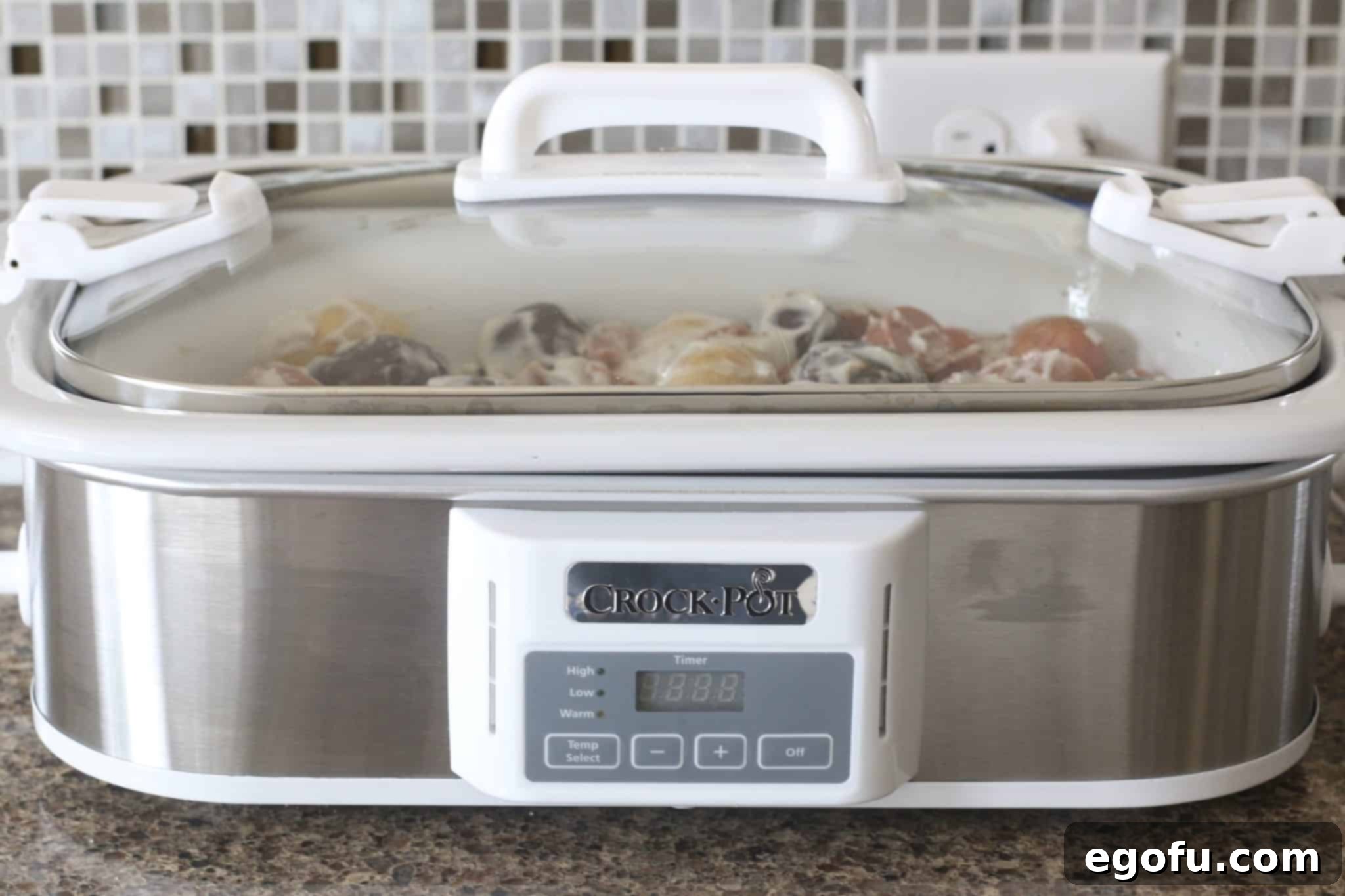 Easy Slow Cooker Creamy Sausage and Potatoes 8 A slow cooker filled with creamy sausage and potatoes, cooked to perfection, with the lid on.