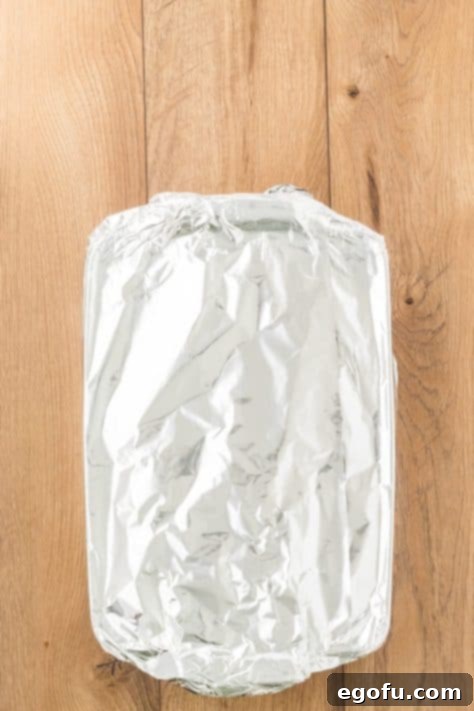 A baking dish of chicken spaghetti covered with aluminum foil.