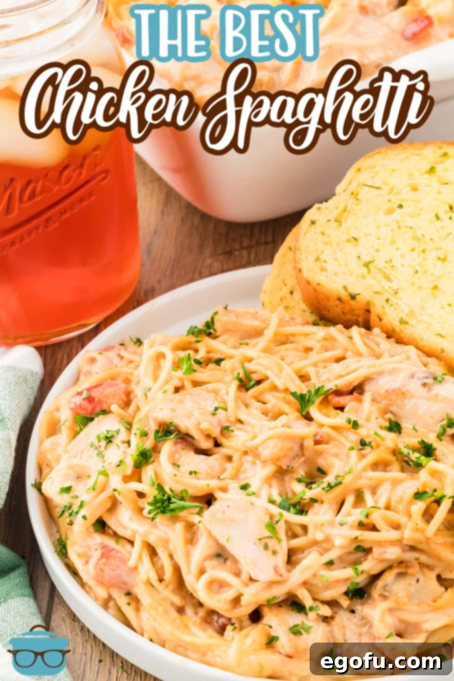 A serving bowl of creamy Chicken Spaghetti paired with a slice of golden garlic bread, ready to be enjoyed.