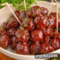 Sweet & Tangy Grape Jelly Meatballs 13 Square image of Homemade Grape Jelly Meatballs in dish with toothpicks.