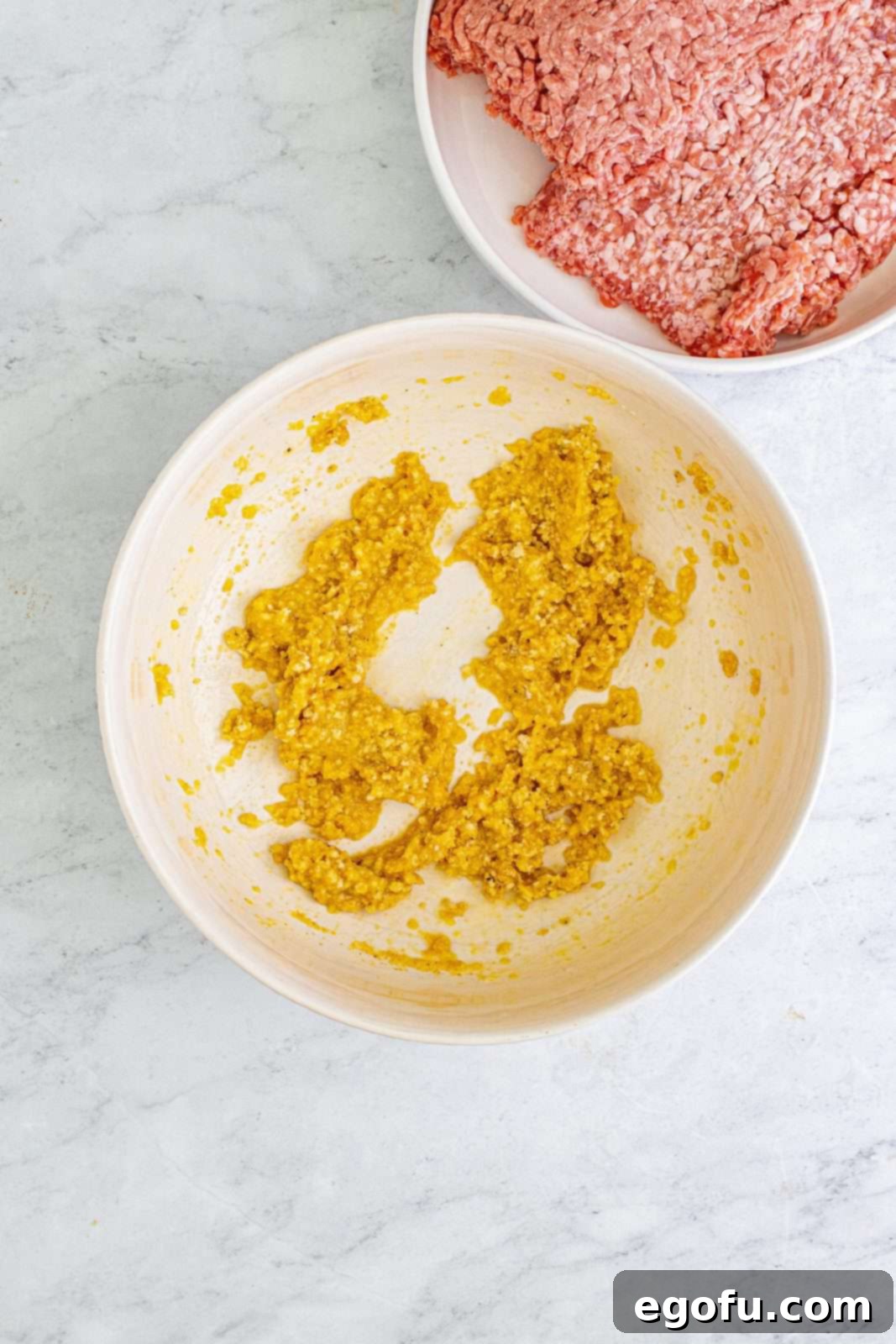 Sweet & Tangy Grape Jelly Meatballs 5 Eggs, breadcrumbs, garlic powder, onion powder, salt, and pepper combined in bowl.