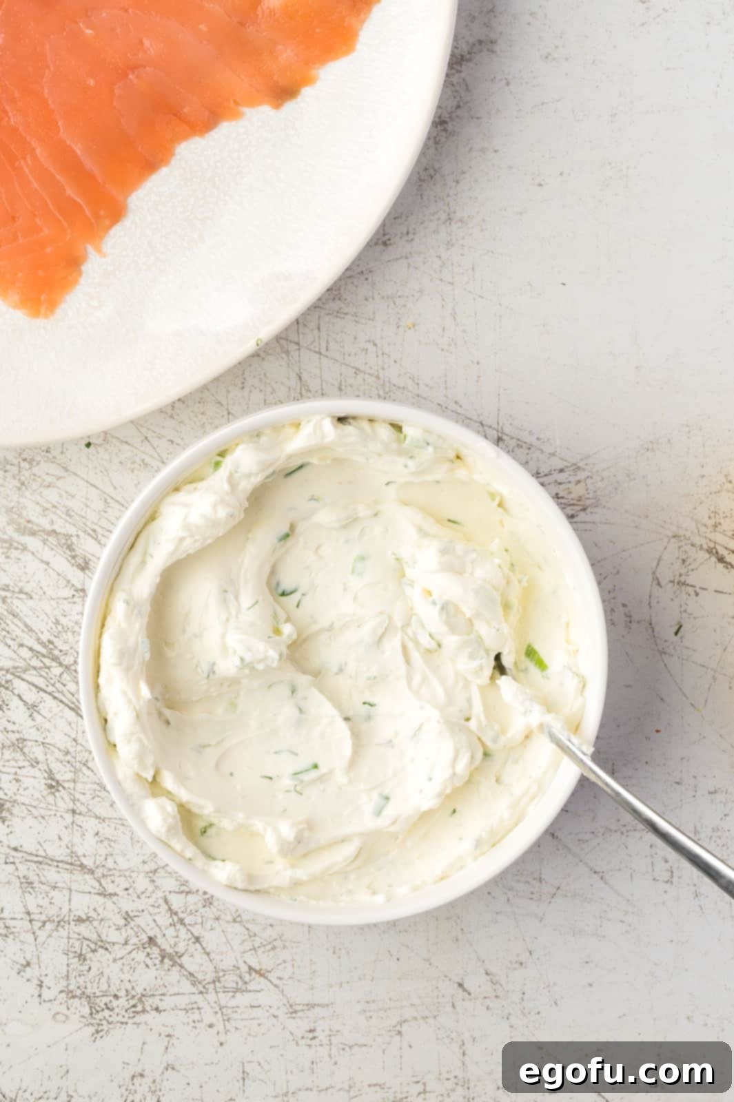 Close-up shot of the creamy horseradish and dill sauce ingredients perfectly mixed together in a white bowl, ready for spreading.