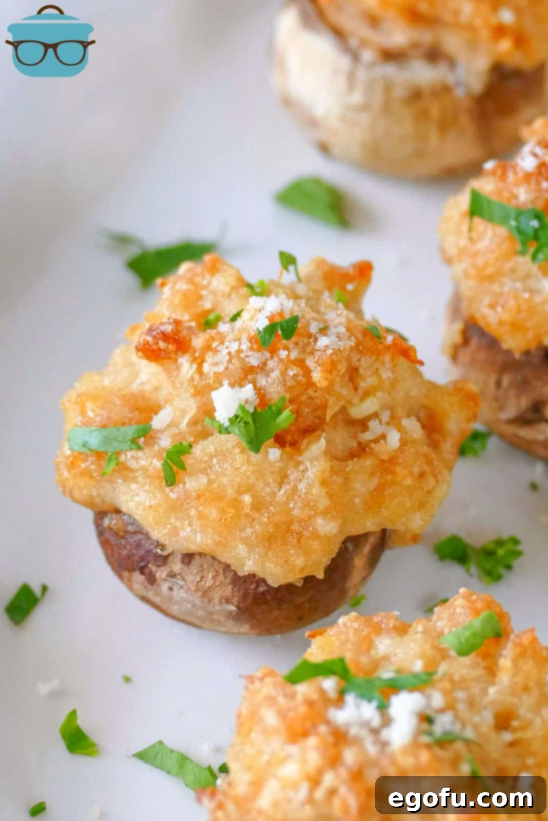 Savory Crab-Filled Mushroom Bites 2 Close up of one Crab Cake Stuffed Mushroom on white plate.