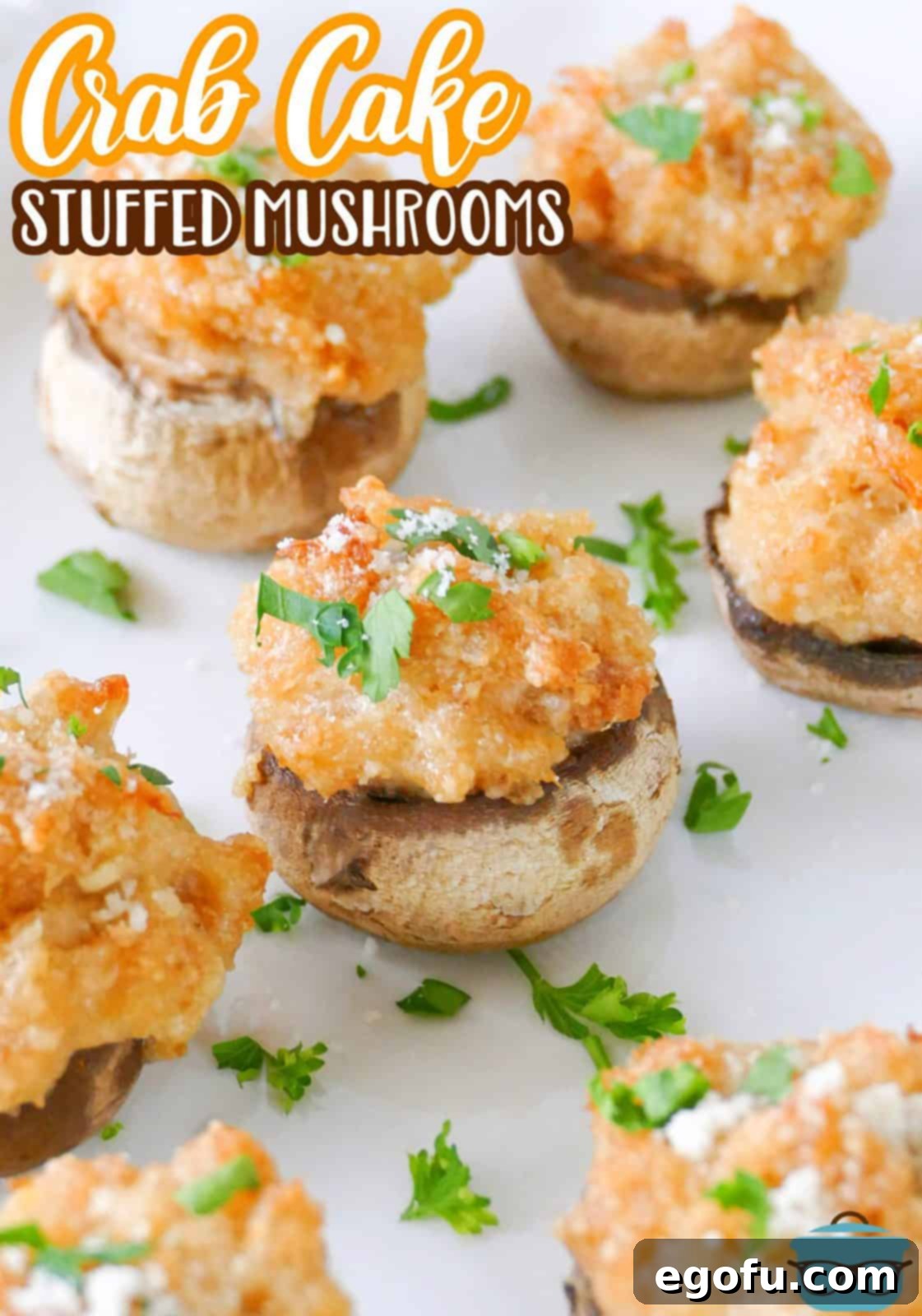 Savory Crab-Filled Mushroom Bites 3 Pinterest image of Crab Cake Stuffed Mushrooms on white plate topped with parsley.