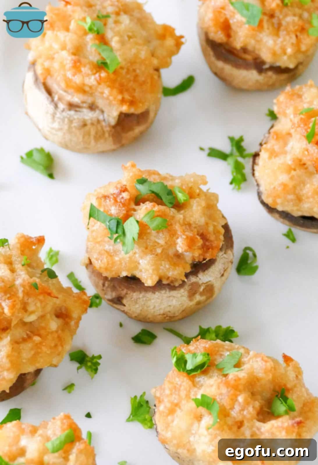 Savory Crab-Filled Mushroom Bites 8 Crab Cake Stuffed Mushrooms on white plate topped with parsley.