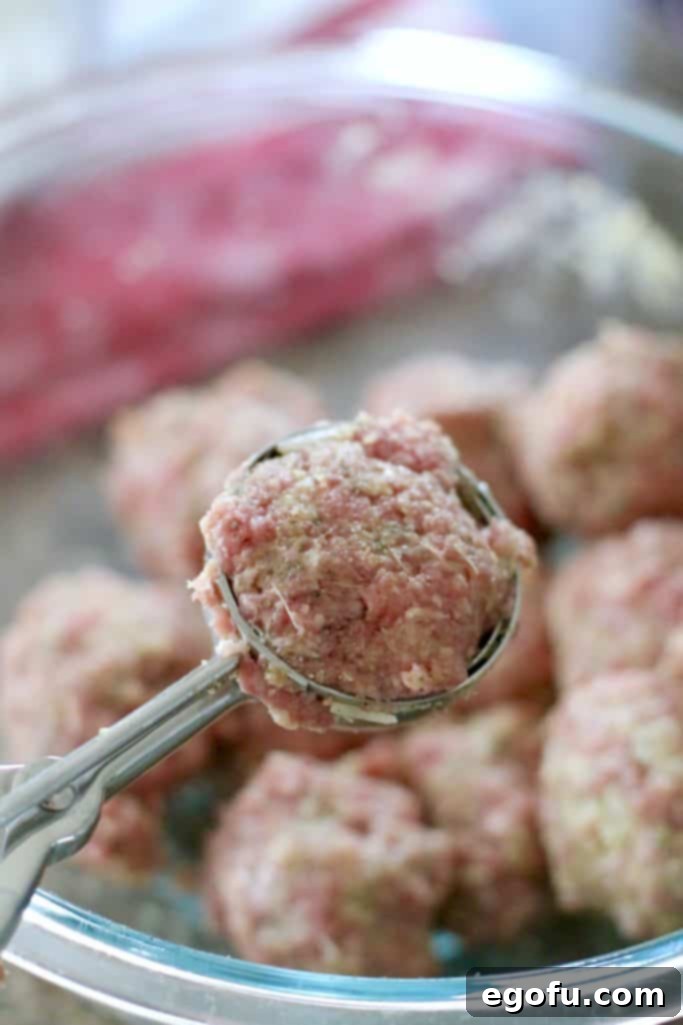 Slow Simmered Homemade Meatballs with Zesty Marinara 11 meatballs being formed using a spring-loaded scooper