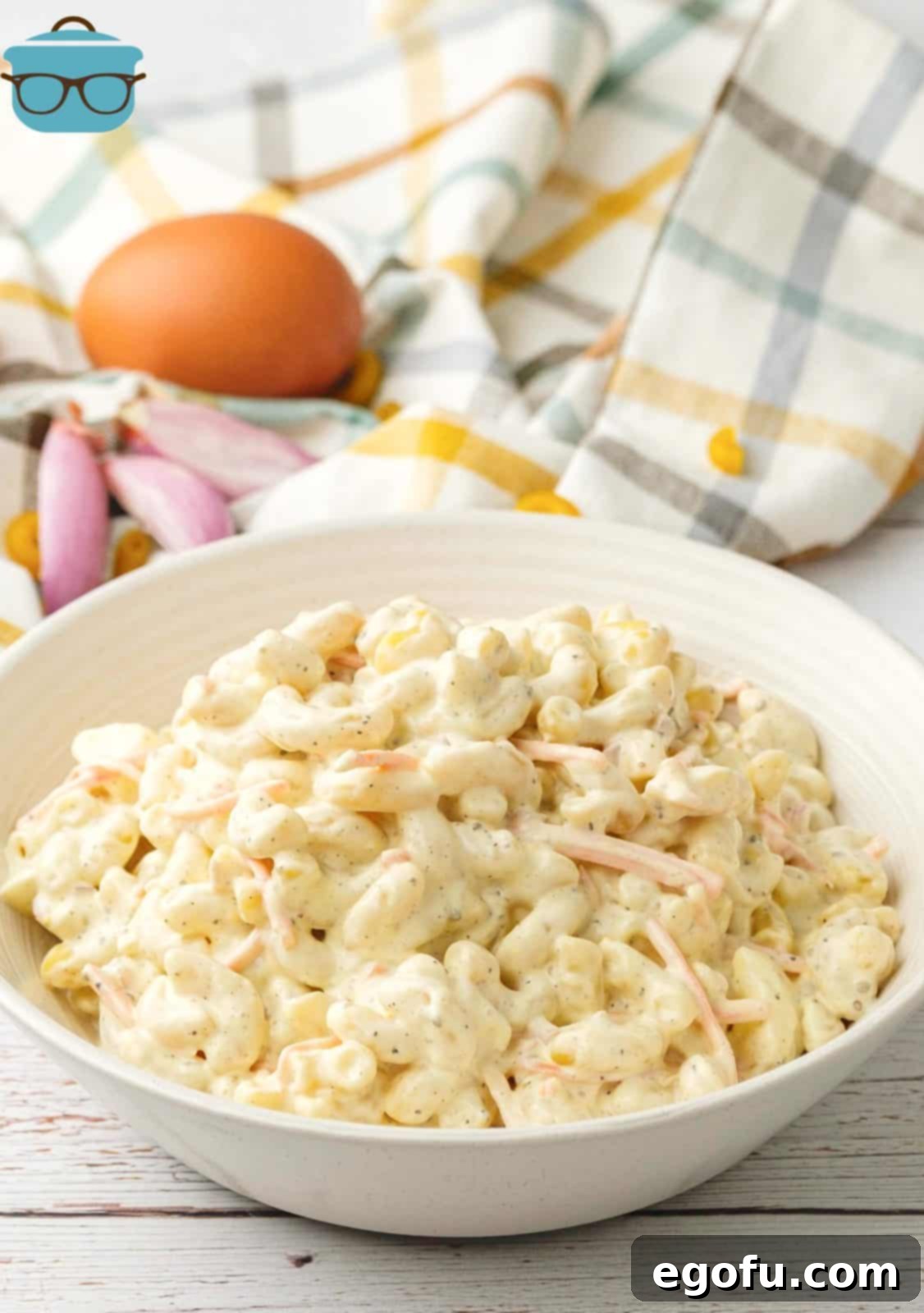 Creamy Hawaiian Macaroni Salad 7 Hawaiian Mac Salad in a shallow white bowl on a white wooden surface.