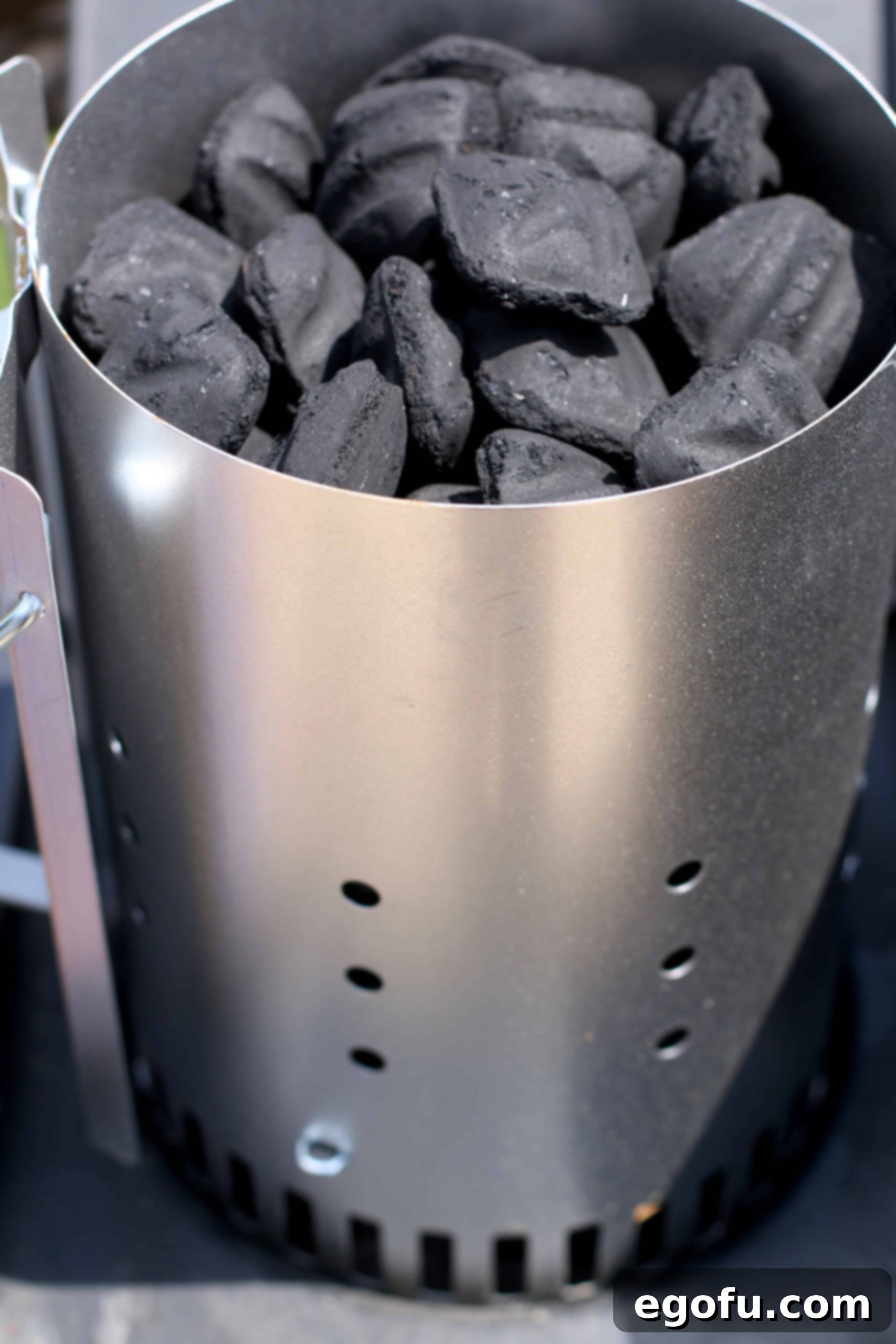 Charcoal briquets loaded into a chimney starter, ready to be lit.