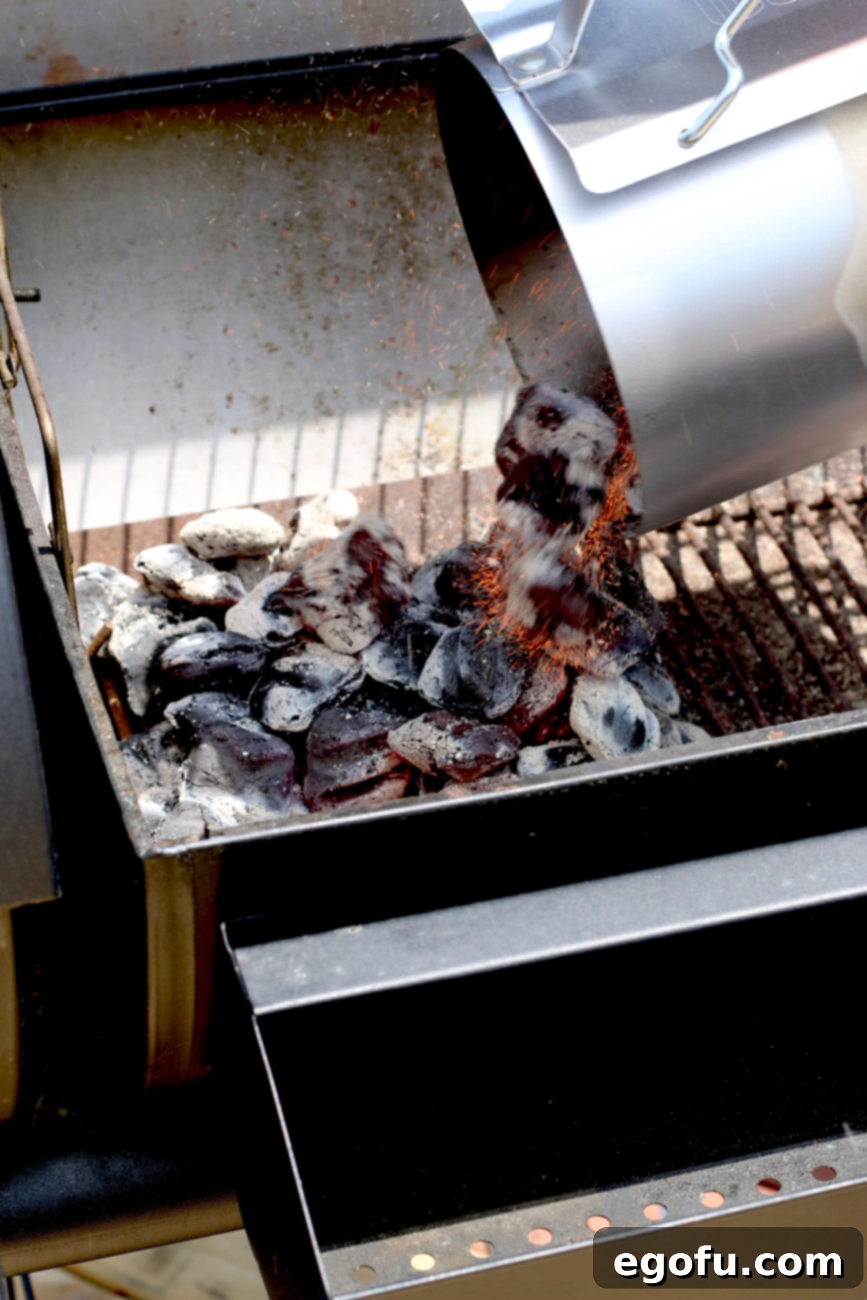 Pouring hot charcoal briquets from a chimney starter onto one side of a charcoal grill, creating two heat zones.