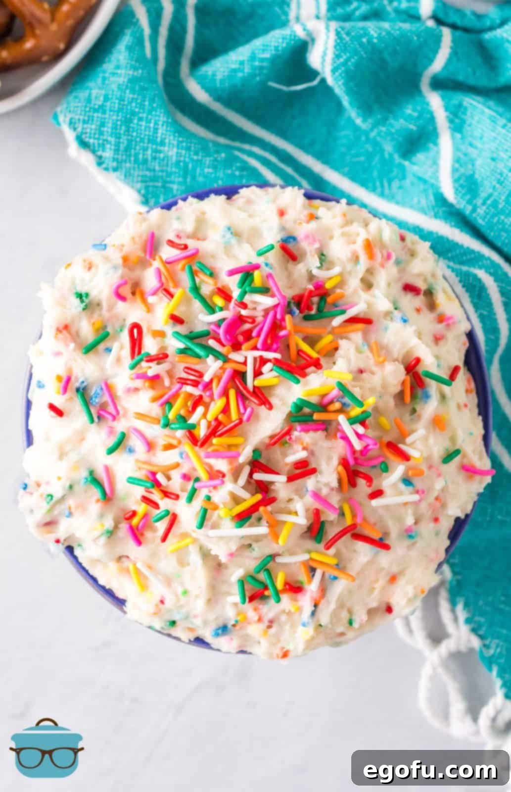 Confetti Cake Bliss 8 Overhead view of the finished Funfetti Cake Batter Dip in a white bowl, generously topped with colorful rainbow sprinkles, ready for serving.