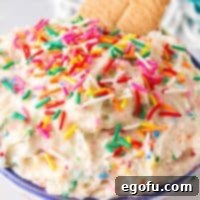 Confetti Cake Bliss 10 Close up square image of Funfetti Cake Batter Dip in bowl with cookies and sprinkles.