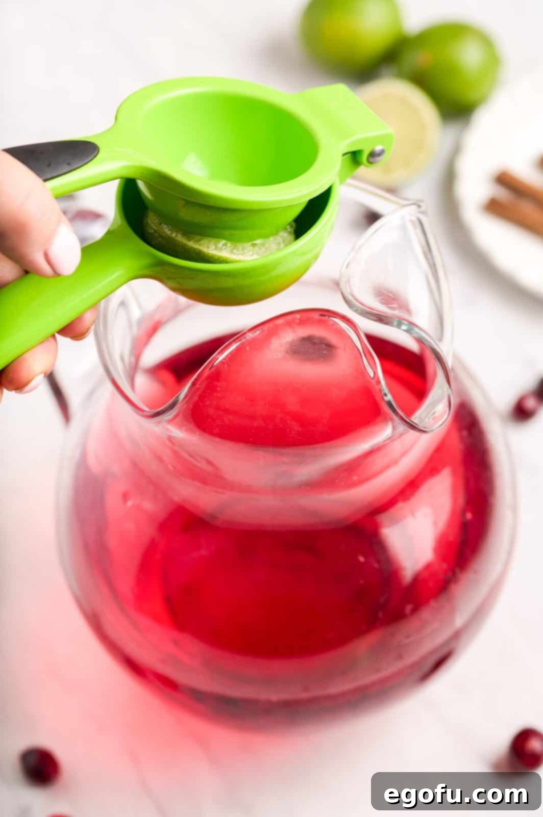Crimson Bubbly 6 Lime juice being squeezed into pitcher. Adding a fresh, zesty flavor to the spritzer.
