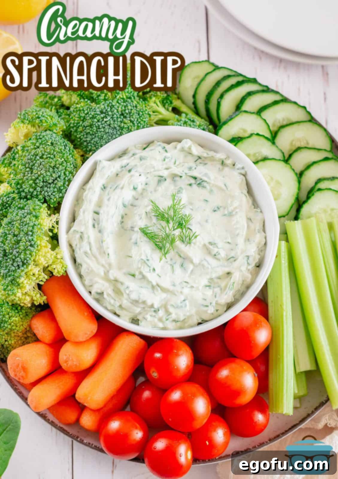 Chilled Garden Spinach Dip 4 A vibrant Pinterest-ready image of Classic Spinach Dip in a elegant white bowl, garnished with fresh herbs, positioned centrally among a colorful assortment of fresh vegetables and crispy crackers.