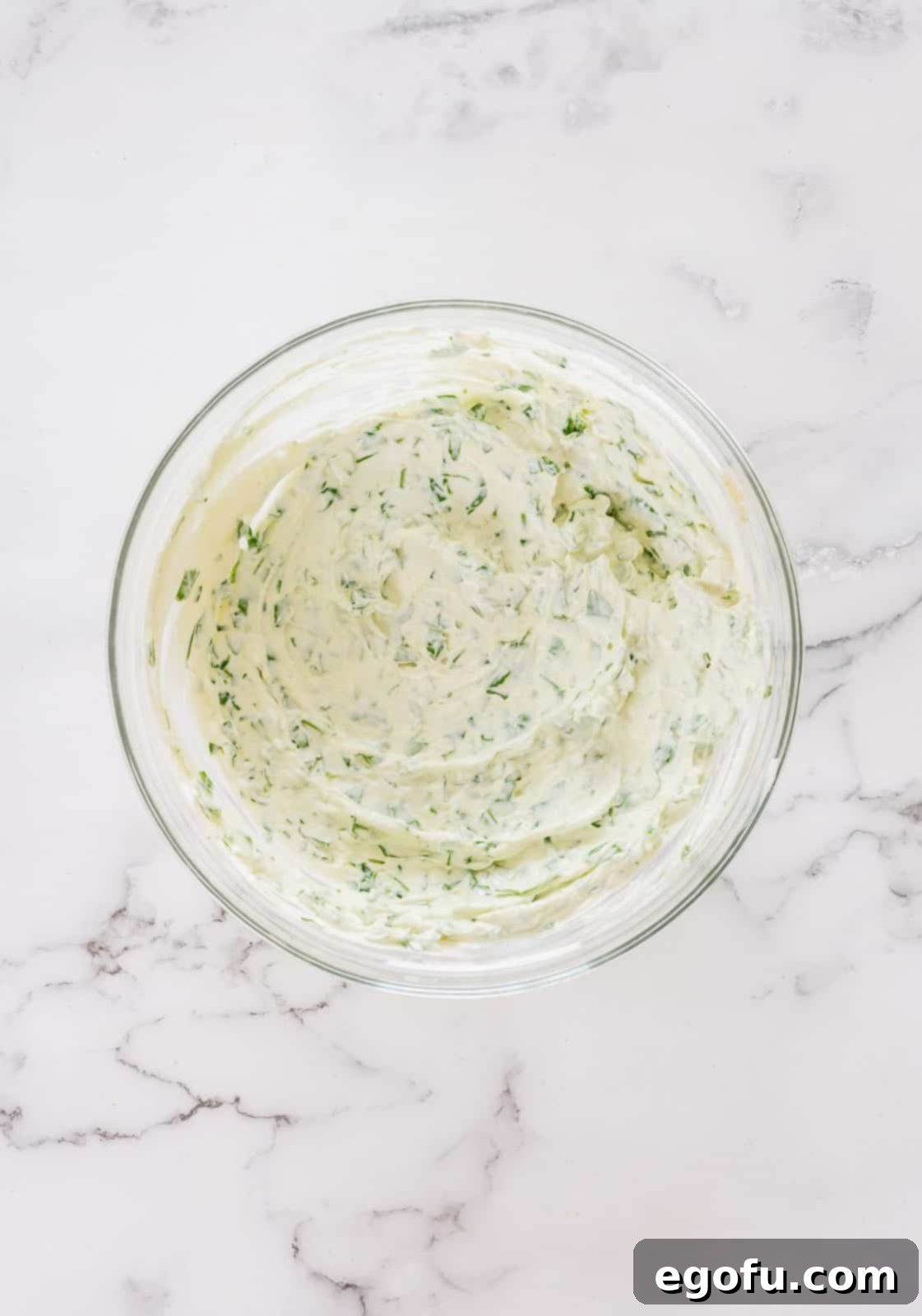 Chilled Garden Spinach Dip 5 A close-up view of the creamy spinach dip mixture in a bowl after all ingredients have been thoroughly combined, showcasing its smooth texture and rich green flecks of spinach.