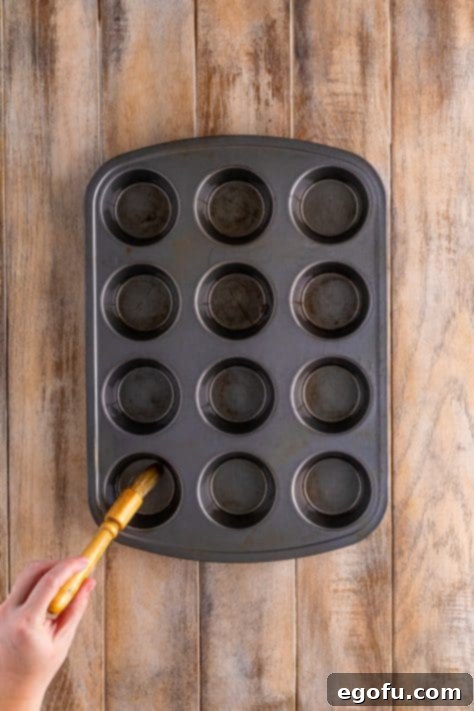 Starbucks' Bite-Sized Egg Delights 12 Egg batter being carefully added to the greased muffin tin wells, filling them partially.