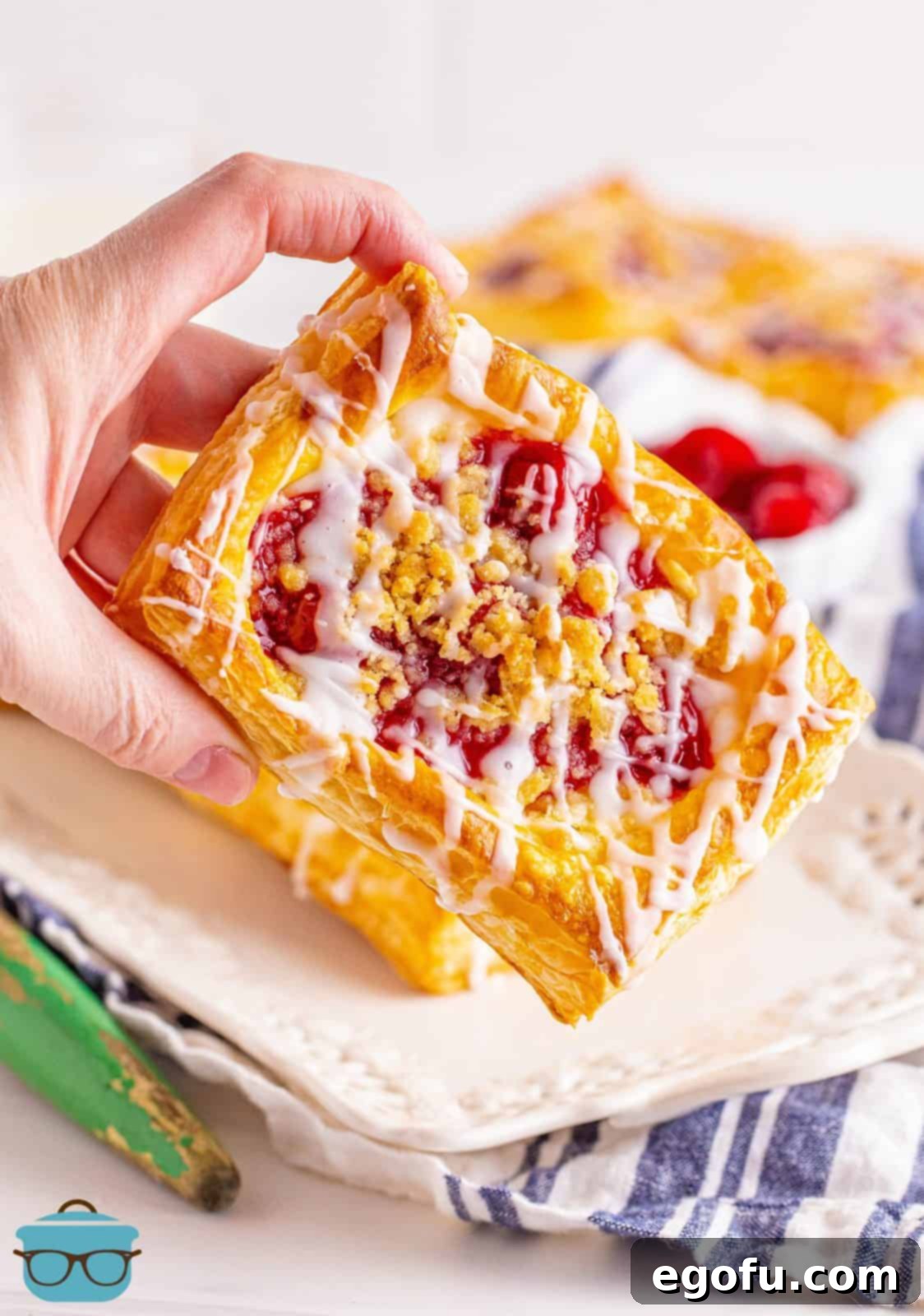 Buttery Cherry Crumble Danishes 15 Hand holding up one Cherry Crumble Daniish.