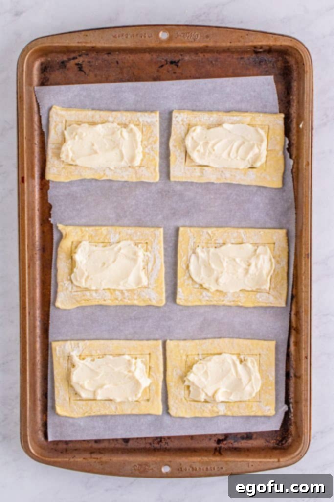 Buttery Cherry Crumble Danishes 9 Cream cheese mixture spread in the middle of puff pastry pieces.