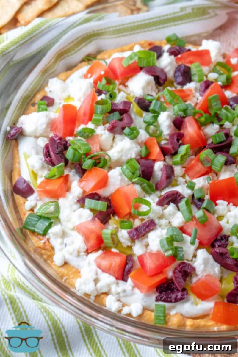 prepared Greek Layered Dip in a clear glass pie pan.
