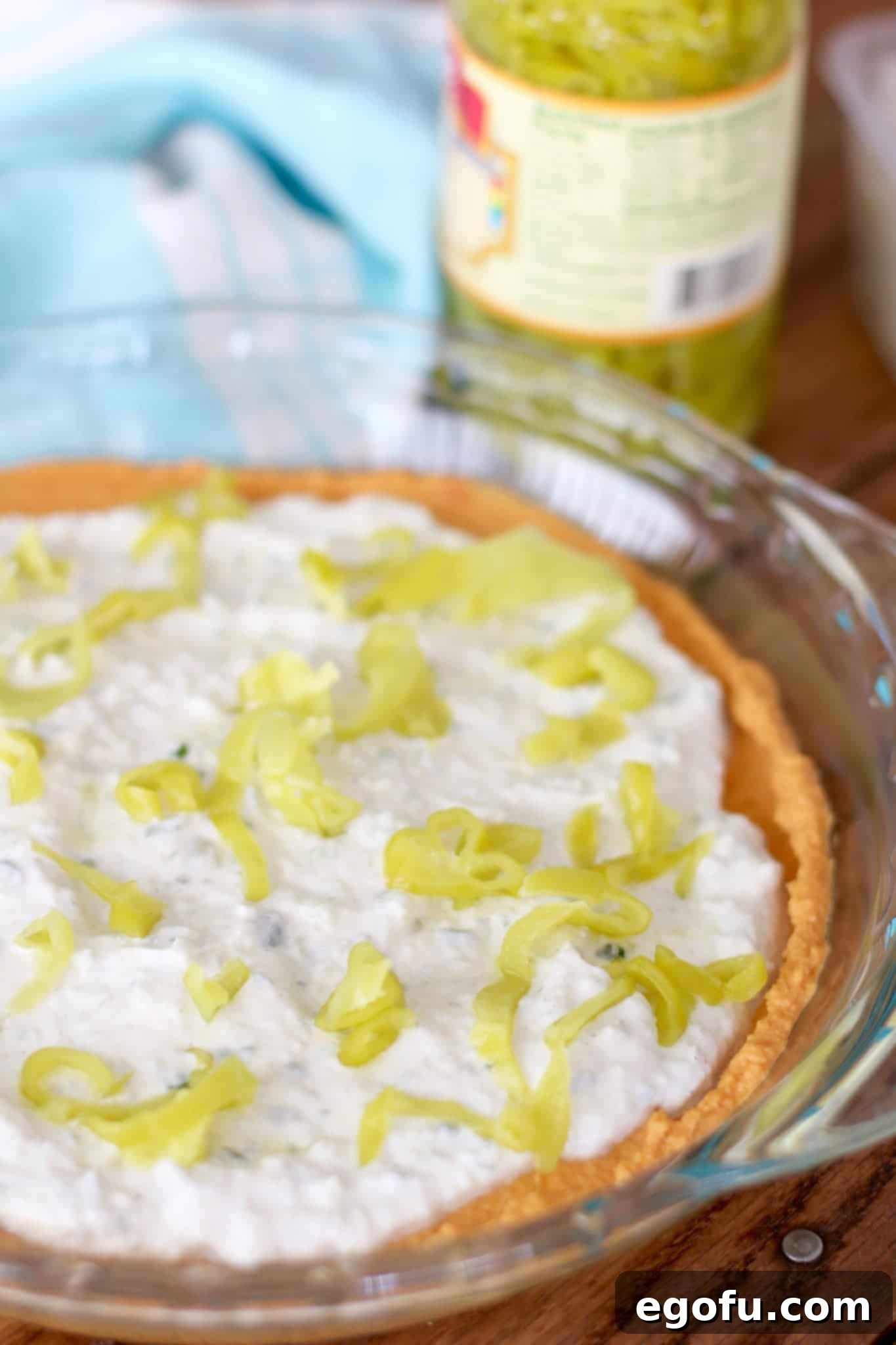 sliced pepperoncini peppers on tzaziki dip and red pepper hummus.