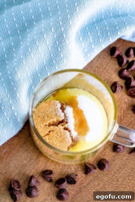 brown sugar and white sugar in a clear mug with melted butter.
