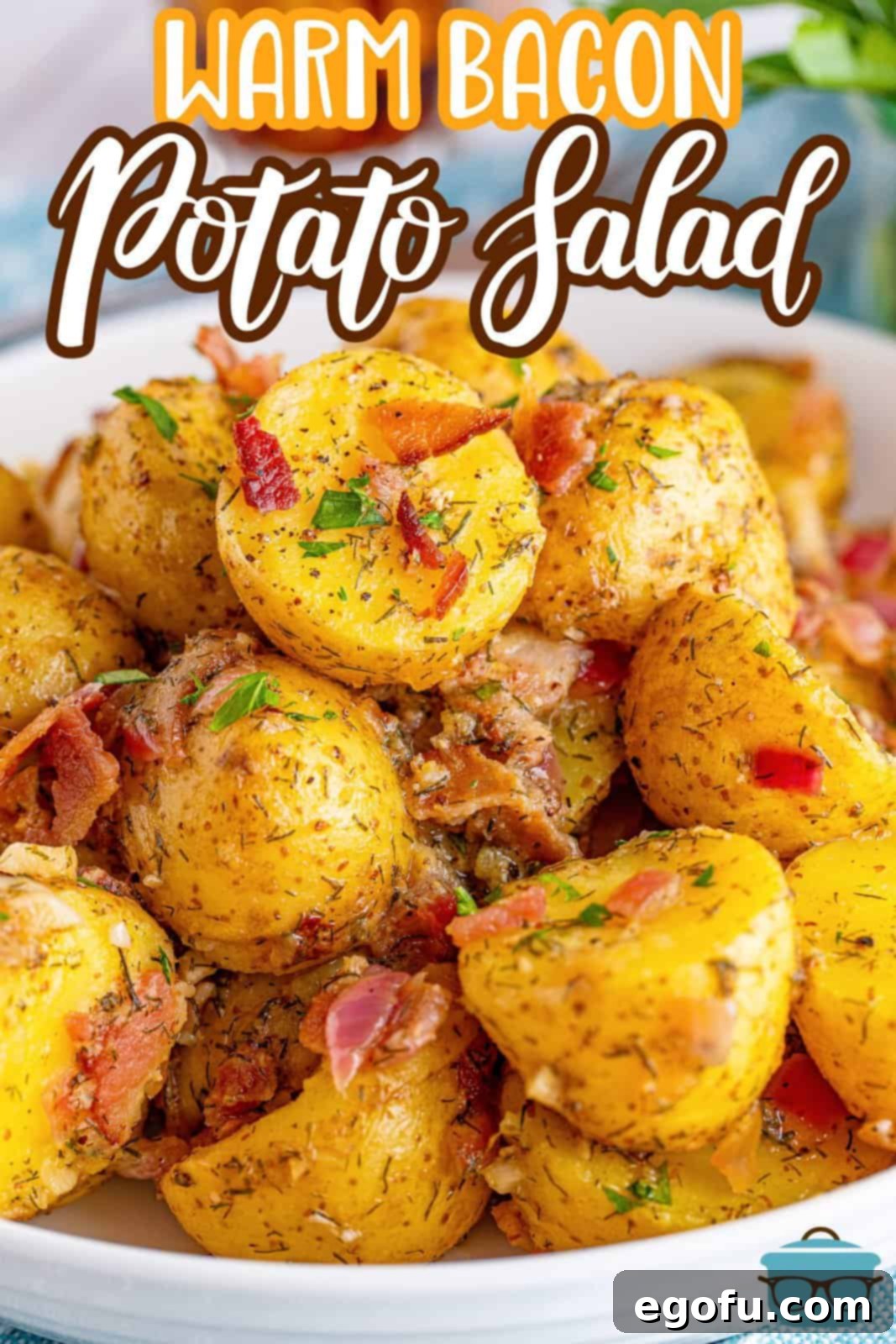 Warm bacon potato salad served in a large white bowl, with fresh parsley sprigs in the background, highlighting its rustic appeal.