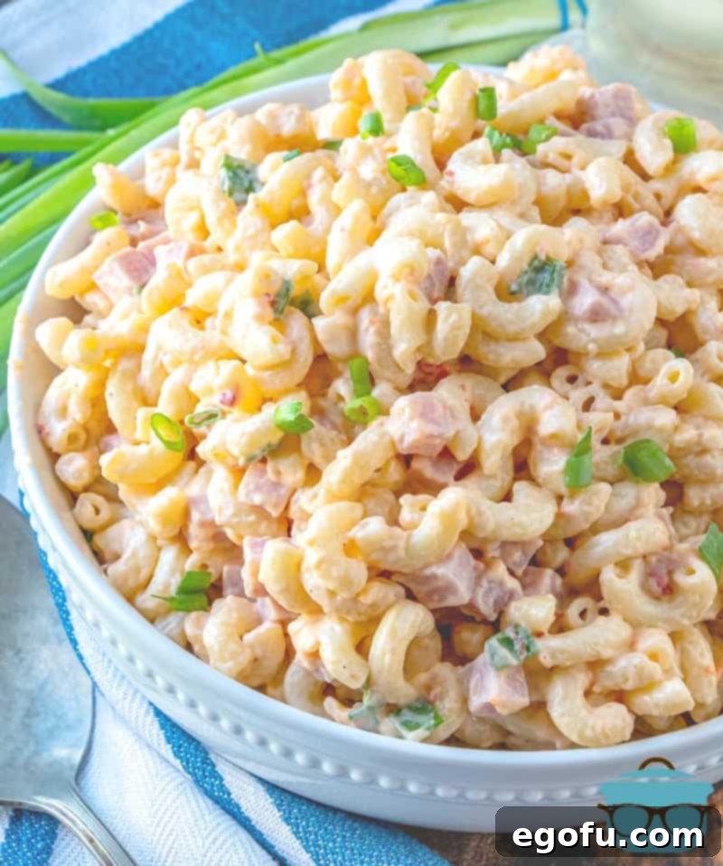 Homestyle Pimiento Macaroni Salad 11 Ham and Cheese Macaroni Salad served in a large white bowl and topped with sliced green onions.