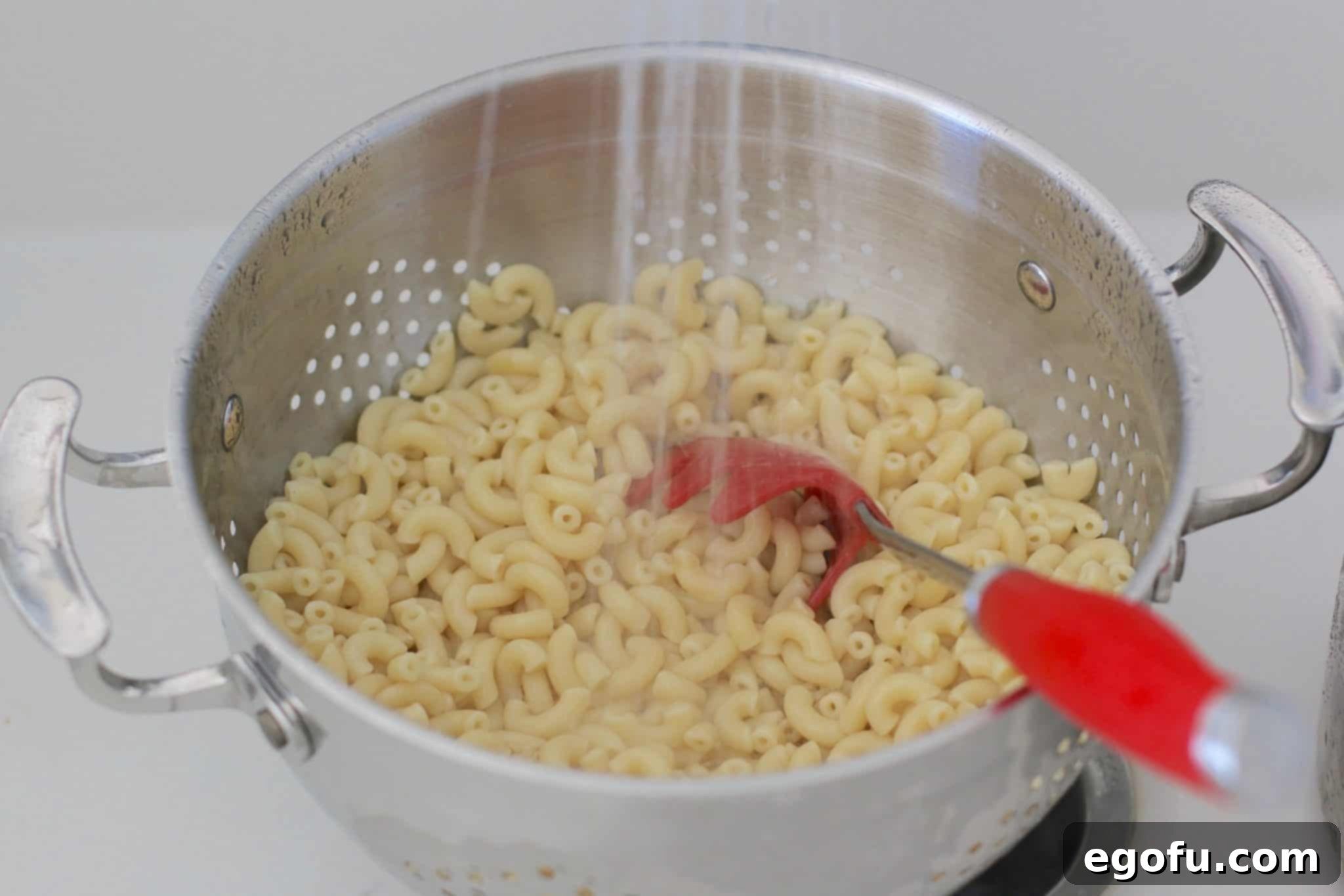 Homestyle Pimiento Macaroni Salad 6 rinsing macaroni noodles in a large colander.